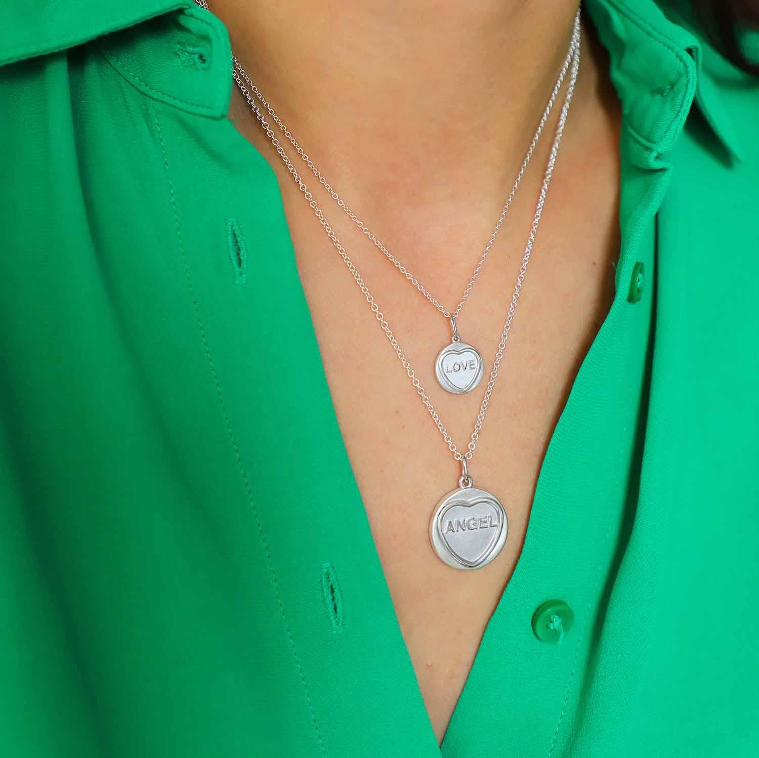 Add a touch of enchantment to your collection with our Angel Silver Love Heart Necklace. This exquisite piece, perfect as a heartfelt gift, is sure to delight. Inspired by the beloved British Love Hearts, the pendant captures nostalgic charm and