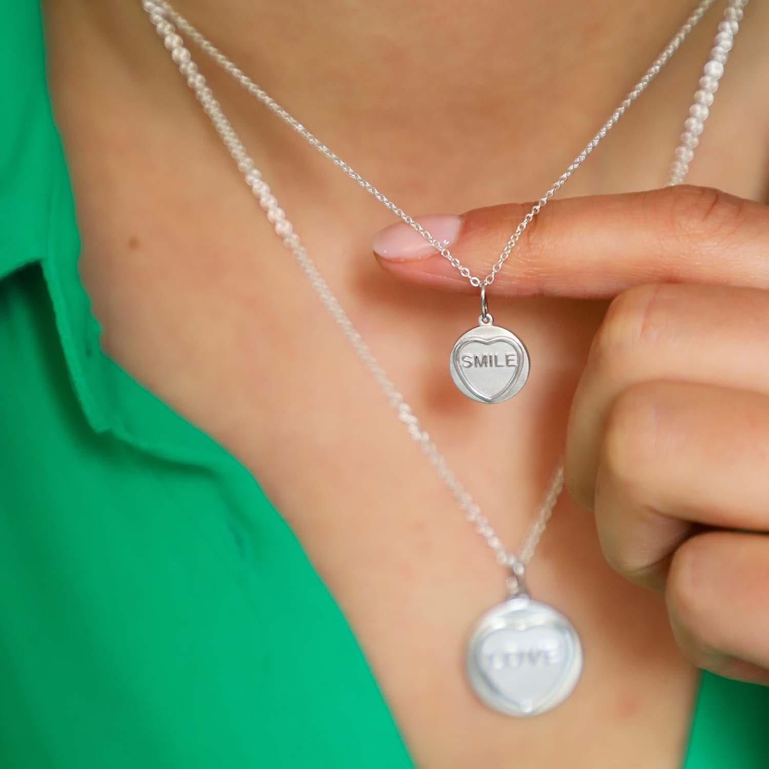 Step into the spotlight with our Smile Silver Love Heart Necklace, designed to bring positivity and charm to your day! This stylish piece, inspired by the beloved Love Hearts sweets, is perfect for adding a touch of nostalgia to your look. Its
