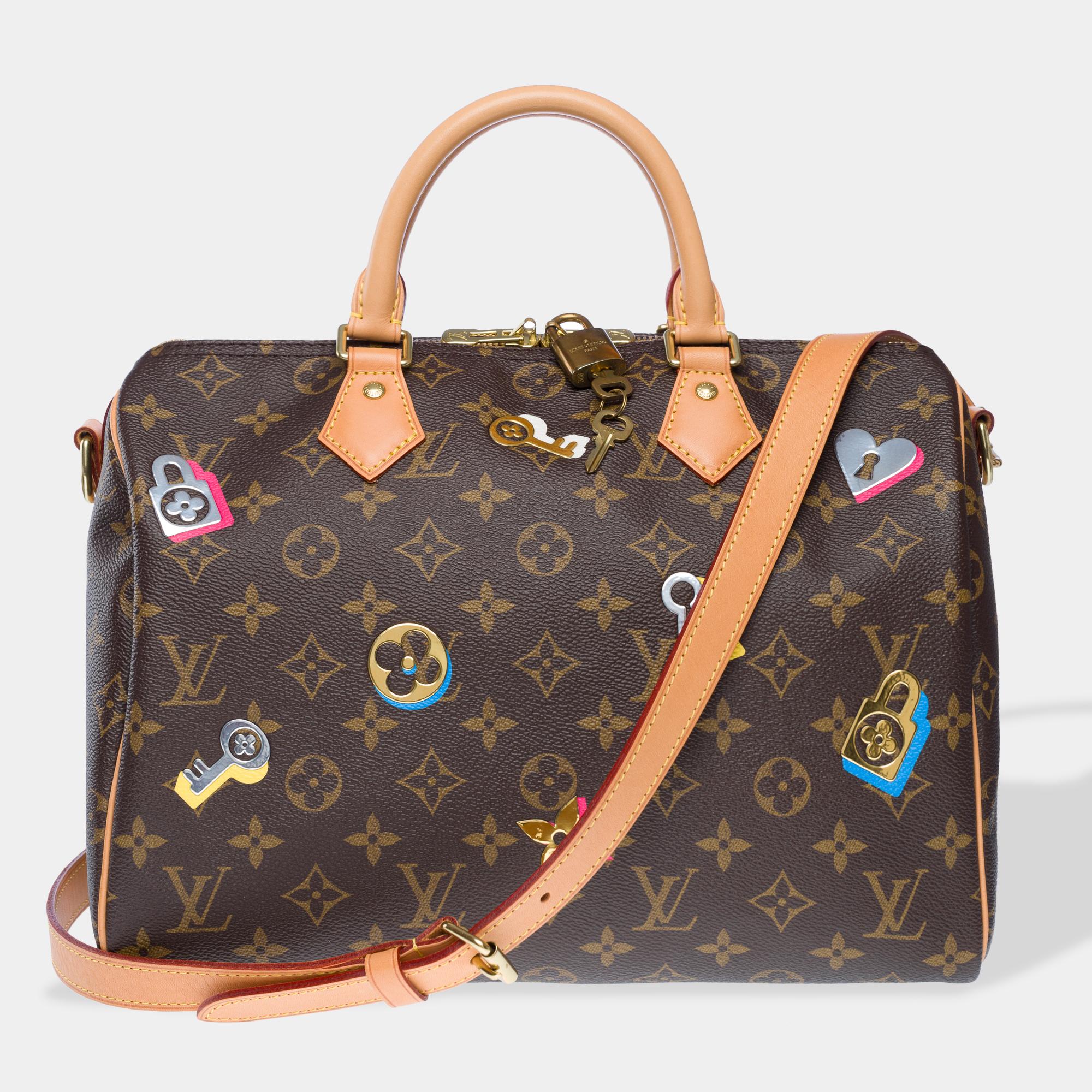 Louis​ ​Vuitton​ ​Speedy​ ​30​ ​limited​ ​edition​ ​Love​ ​Lock​ ​handbag​ ​strap​ ​in​ ​brown​ ​Monogram​ ​canvas,​ ​with​ ​gold​ ​metal​ ​hardware,​ ​double​ ​beige​ ​leather​ ​handles,​ ​and​ ​removable​ ​natural​ ​leather​ ​shoulder​ ​strap​