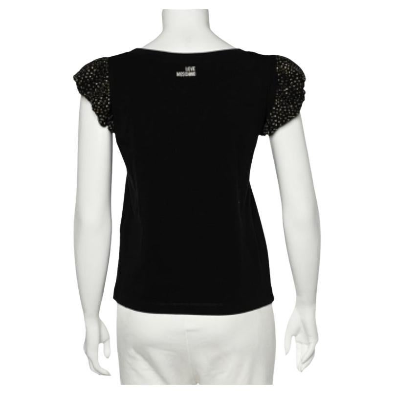 Questa T-shirt di Love Moschino aggiungerà un tocco femminile al tuo aspetto. È sapientemente realizzato in maglia di cotone nero con maniche a sbuffo impreziosite che ne esaltano la bellezza. Sfoggia un look semplice ma elegante indossando questa