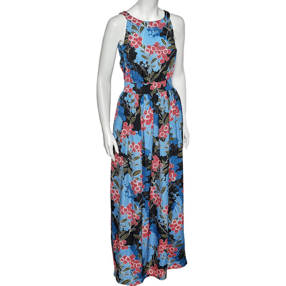En enfilant cette merveilleuse création de la maison Moschino, votre style estival sera rajeuni et classieux ! Cette robe est cousue à partir d'un tissu de crêpe imprimé de fleurs bleues dans une forme maxi-longue chic. Pour la fermeture, il est