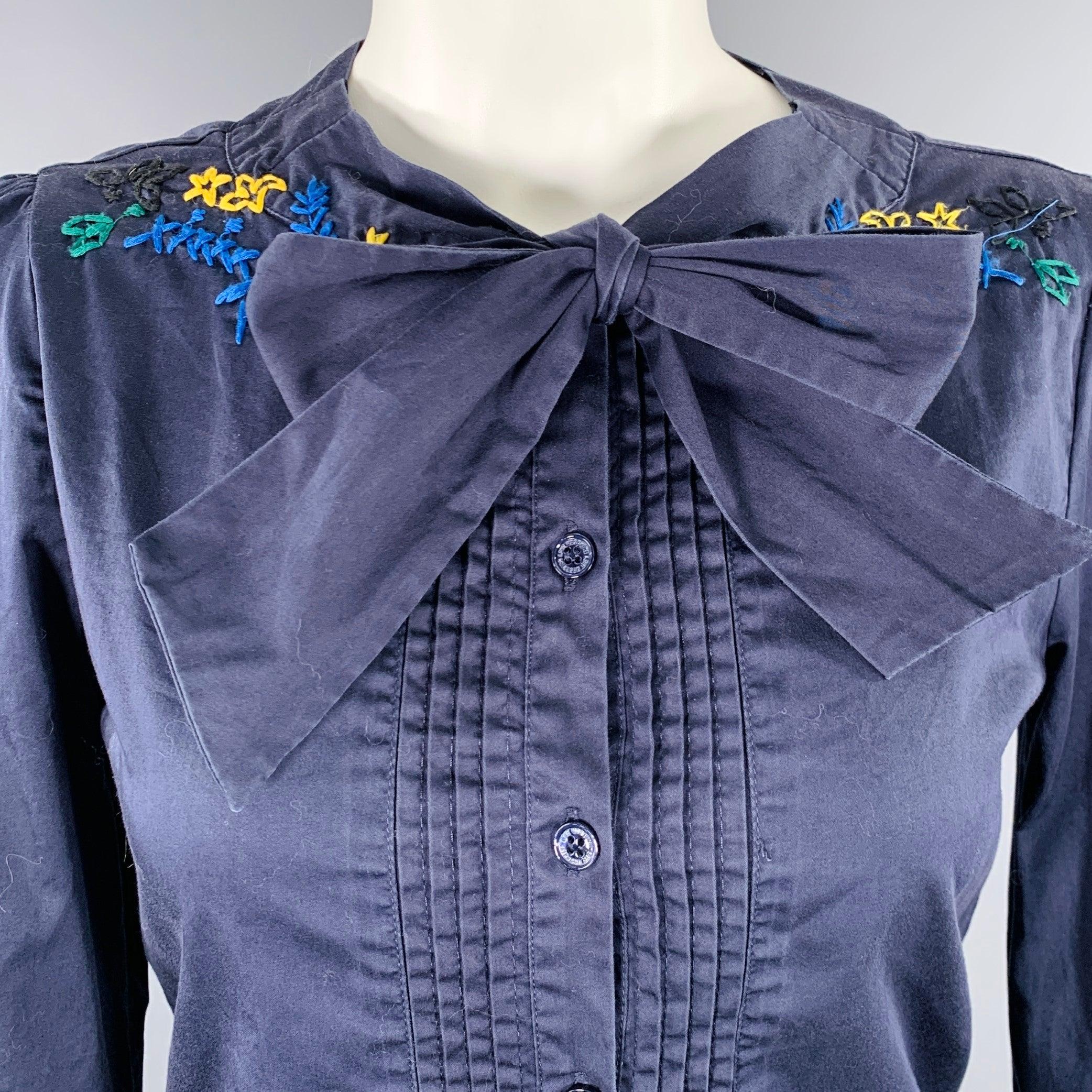 LOVE MOSCHINO casual top
in a navy cotton blend woven fabric featuring a multi-color embroidered neckline, pussybow tie, and long placket button closure with pleated front.Excellent Pre-Owned Condition. 

Marked:   IT 40 

Measurements: 
 
Shoulder: