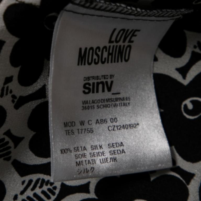 Mit diesem Oberteil aus dem Hause Love Moschino werden Sie wunderschön aussehen. Es ist aus weißem Seidenstoff mit Blumendruck gefertigt, der mit aufwendigen Stickereien verziert ist. Es hat einen ärmellosen Schnitt.