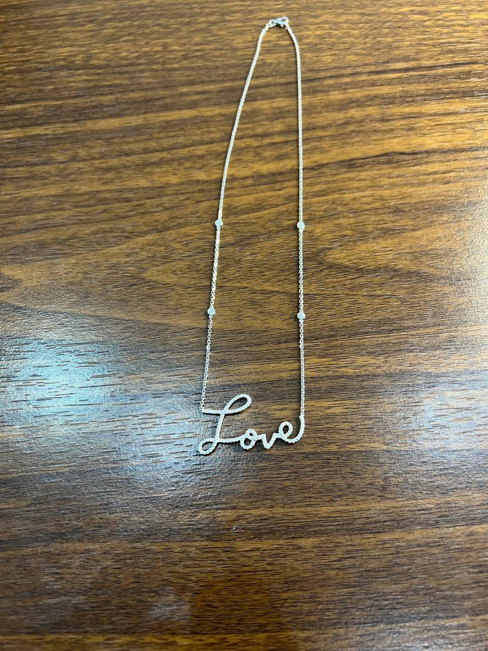 Crafted in 18K White Gold, this elegant piece features the word 