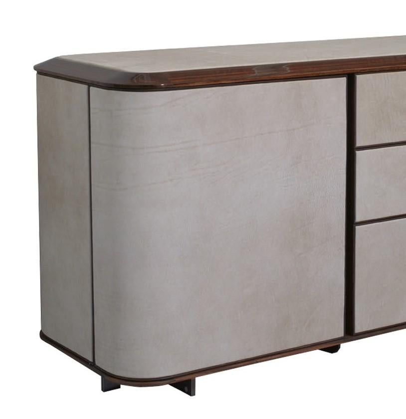 Part of the Love collection that features wood upholstered with light-colored leather, this sideboard features a wood structure in the shape of an elongated rectangular with the Ulivi's signature round corners. The side doors and the panels of the