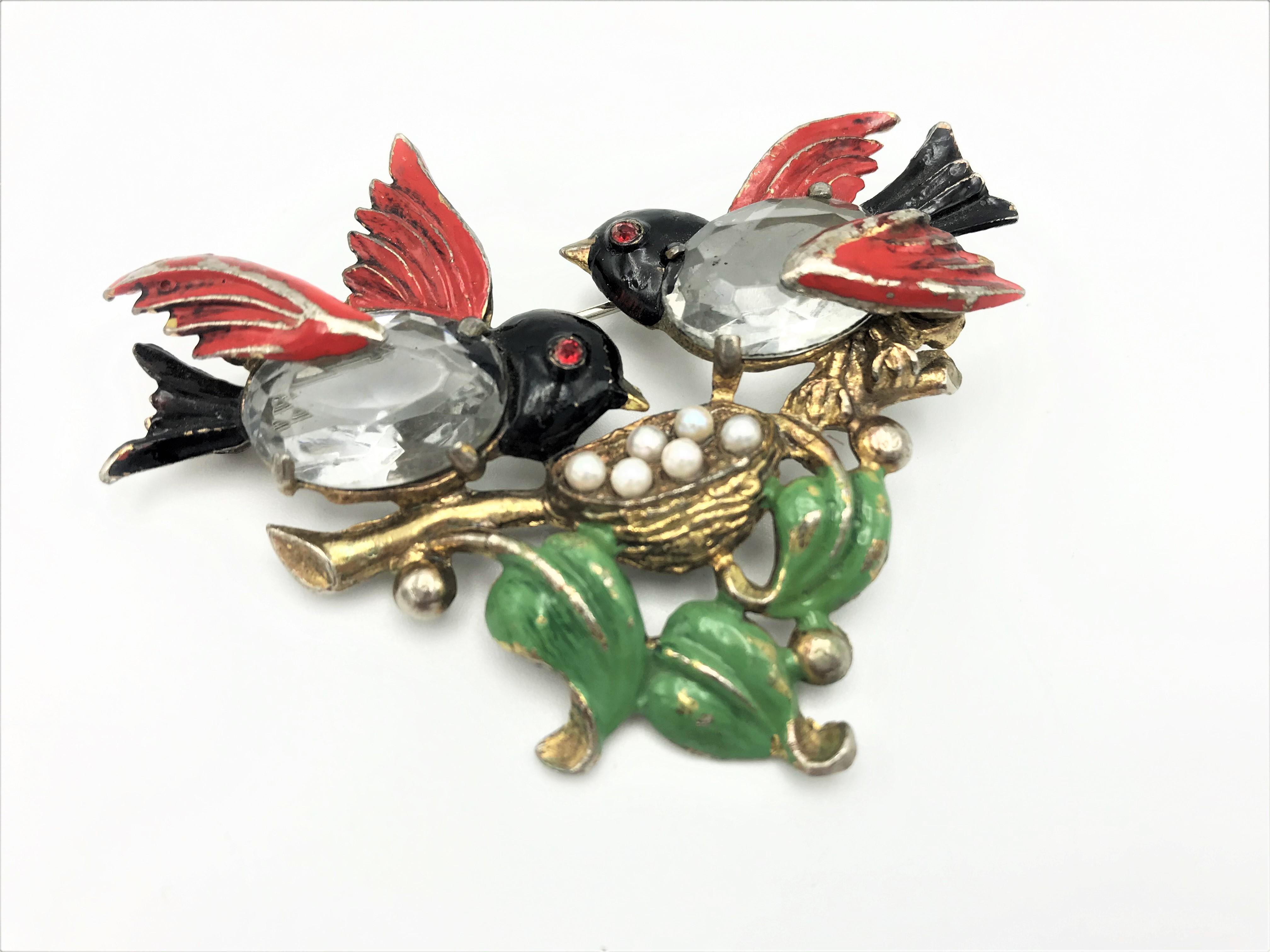 A lovable brooch with 2 birds that take care of their treasure together!
The parents of the birds sit on a branch and take care of their eggs. The bodies of the 2 birds are made of 2 polished rhinestones, the wings, head and tails and the leaves are