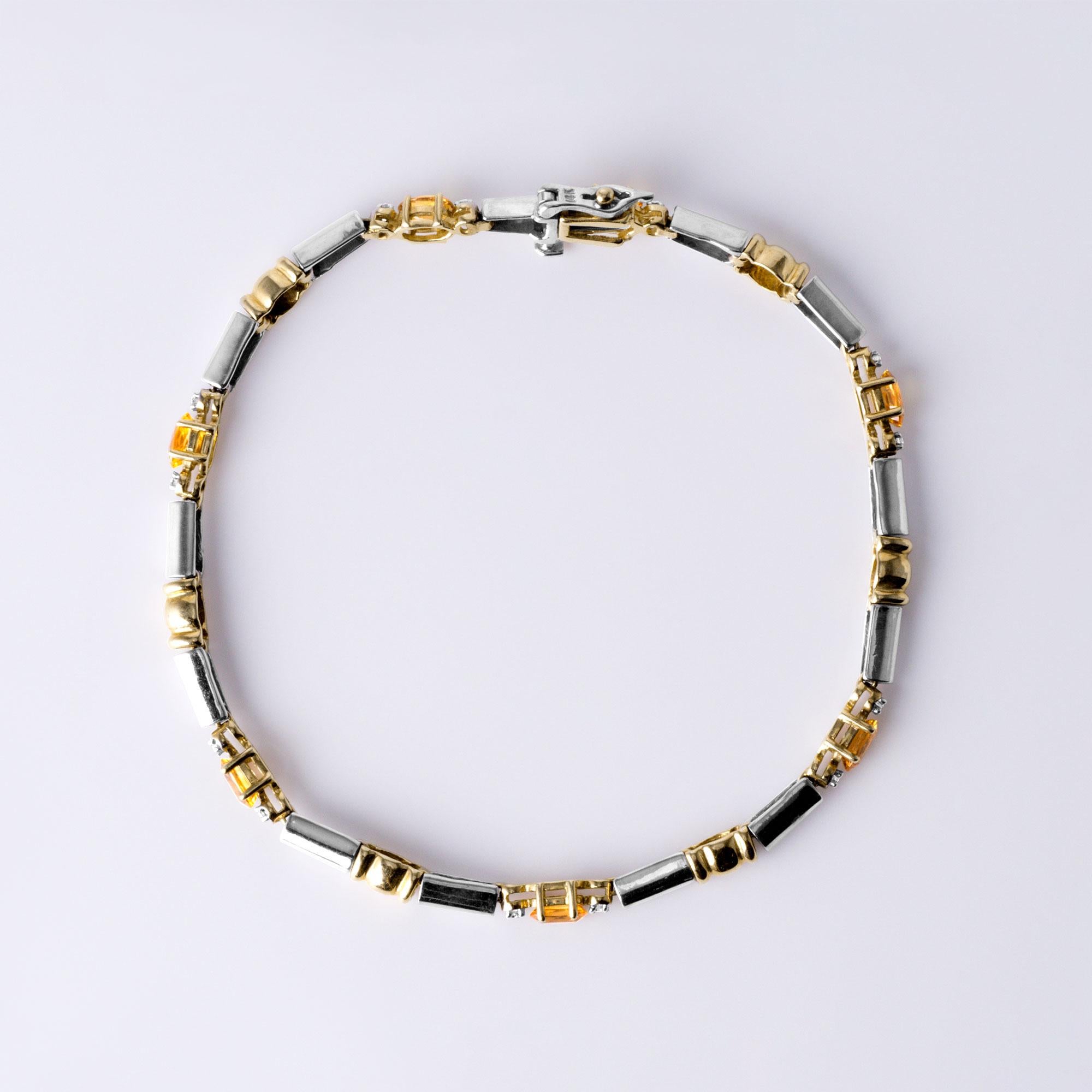 Cet élégant bracelet en or bicolore apporte une touche de couleur sophistiquée à toute collection de bijoux fins. Réalisé en or massif 14 carats et pesant 10 grammes, ce modèle présente sept saphirs jaunes naturels de taille ovale, totalisant