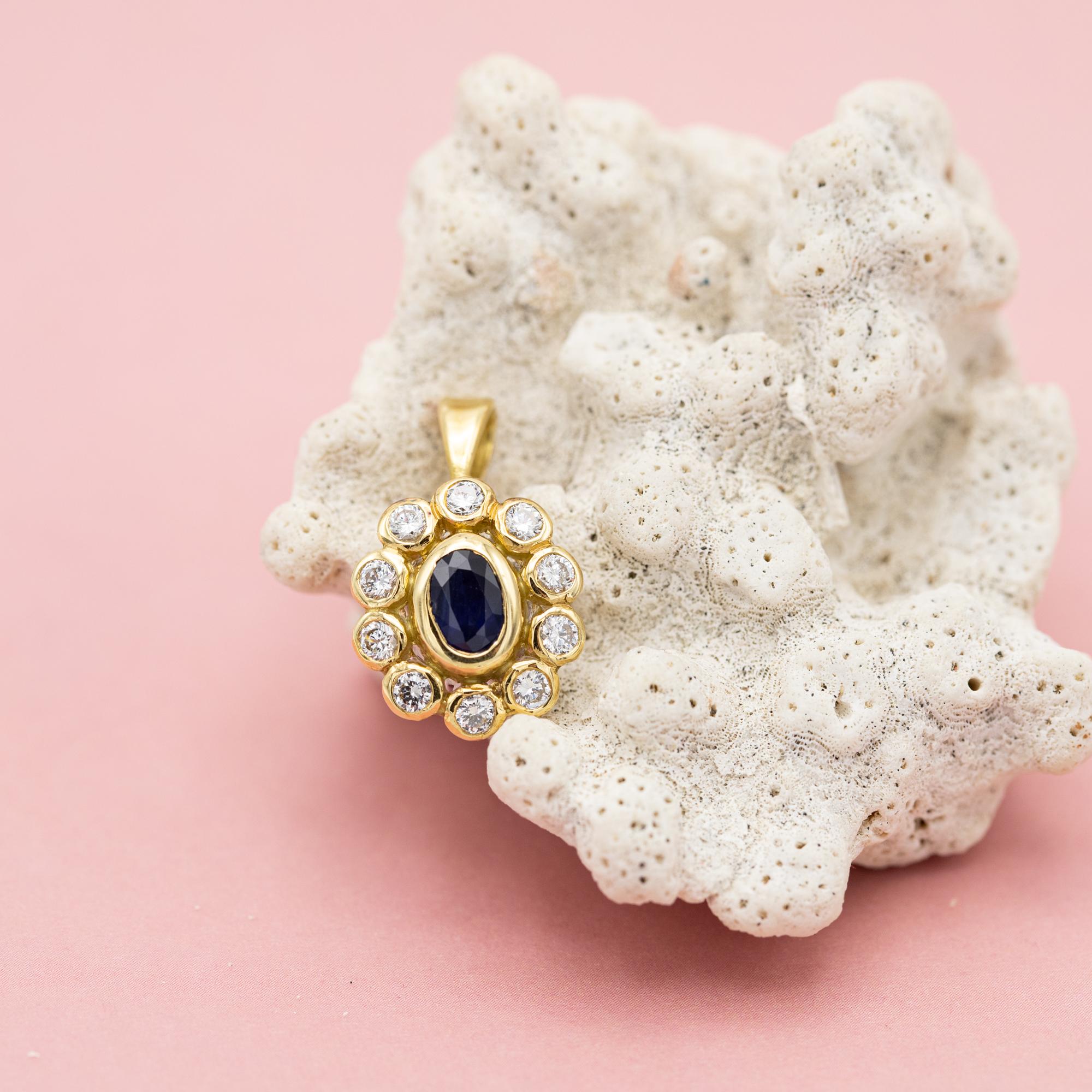 Zu verkaufen ist diese wunderbare floral Cluster Charme. Dieser Charme aus Diamanten und Saphiren zeigt eine wunderschöne kleine Blume, die in der Mitte mit zehn funkelnden Diamanten im Brillantschliff und einem Saphir im Ovalschliff besetzt ist.