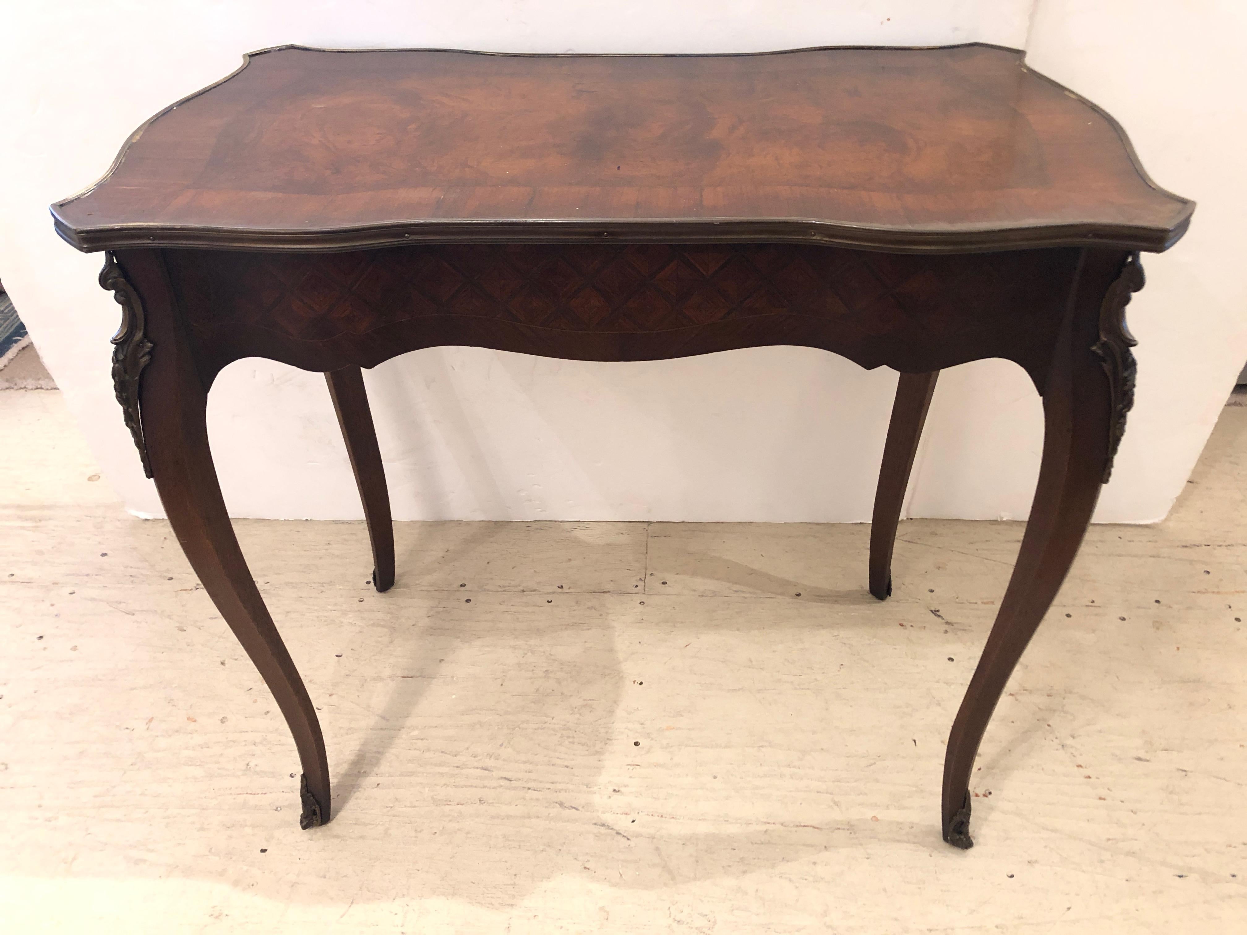 A wonderful small size writing desk, finished on all sides with beautiful mahogany inlaid marquetry, a burl wood top with brass gallery, and having a single large drawer with excellent dovetailing, ormalu mounts, and elegant cabriole legs. Could be