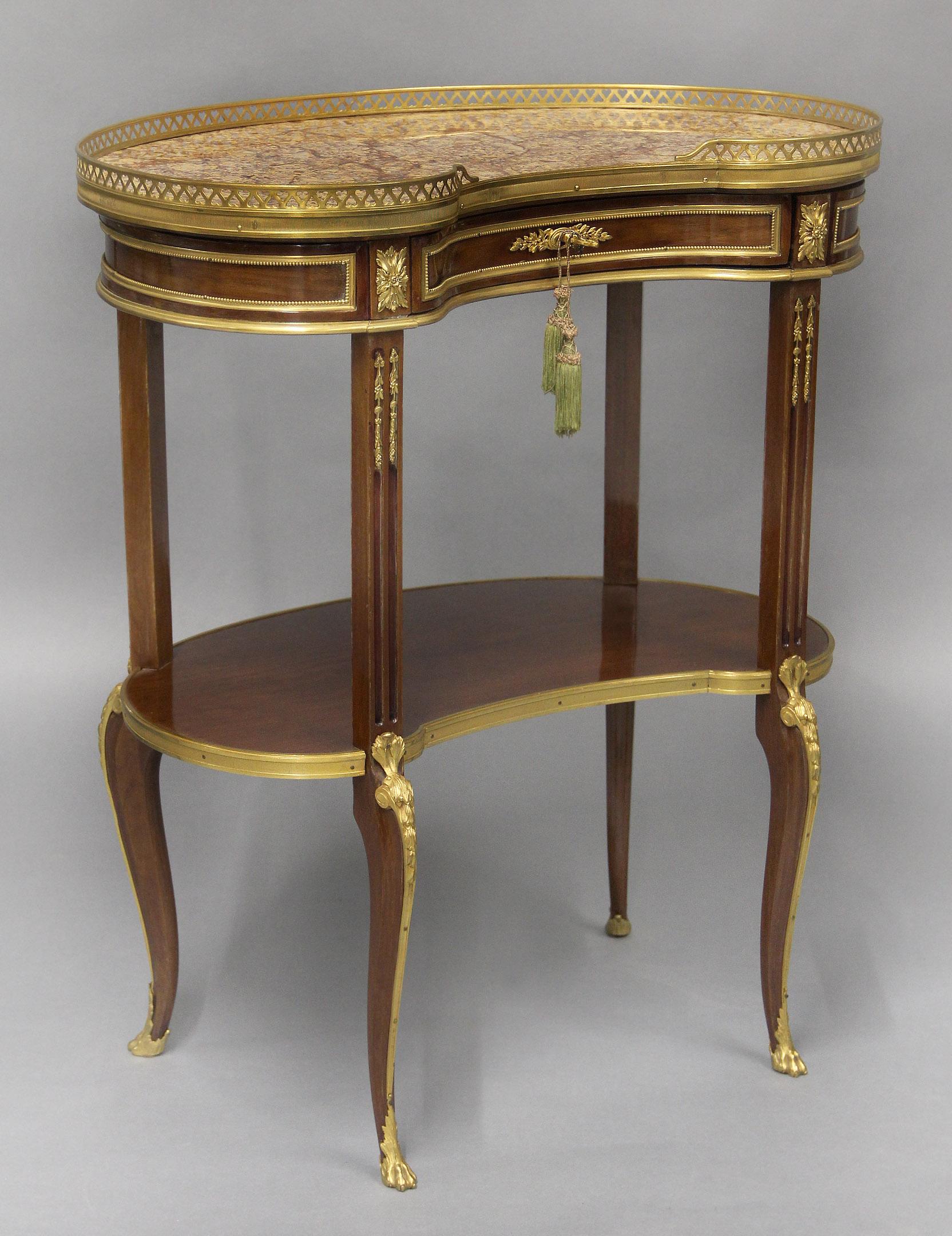Magnifique table d'appoint en forme de rein en acajou, montée sur bronze doré, de style transitionnel de la fin du 19e siècle

Le plateau en marbre brocatelle violette d'Espagne, avec une galerie percée en trois quarts, centré sur le devant par un