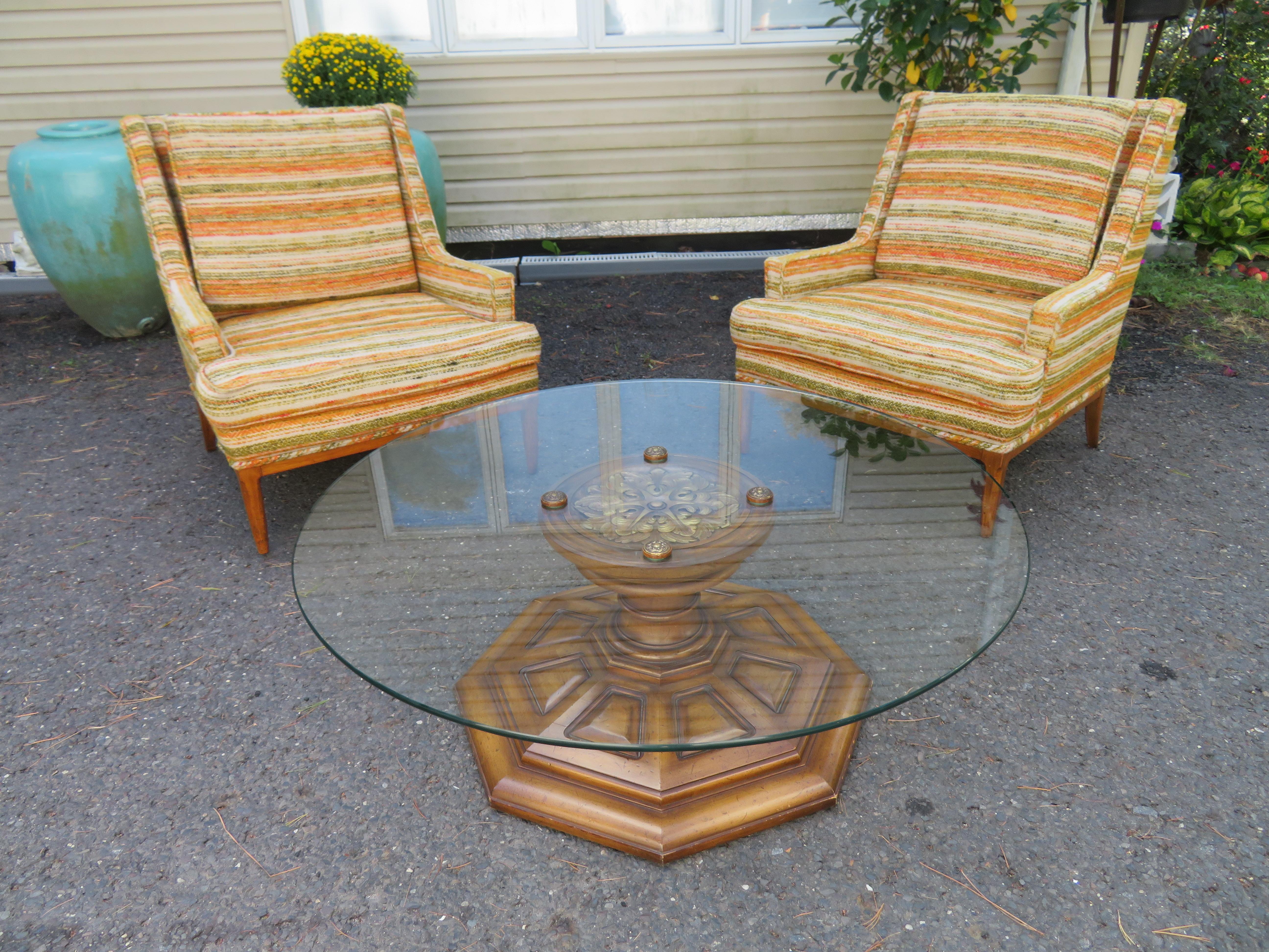 Stylish carved pedestal base coffee table by Weiman. We love the 4 round metalwork rondels of neoclassical motifs highlighting the glass top. The base has mitred pie formation carved panels, semi-gloss finishing, and faux distress painted technique