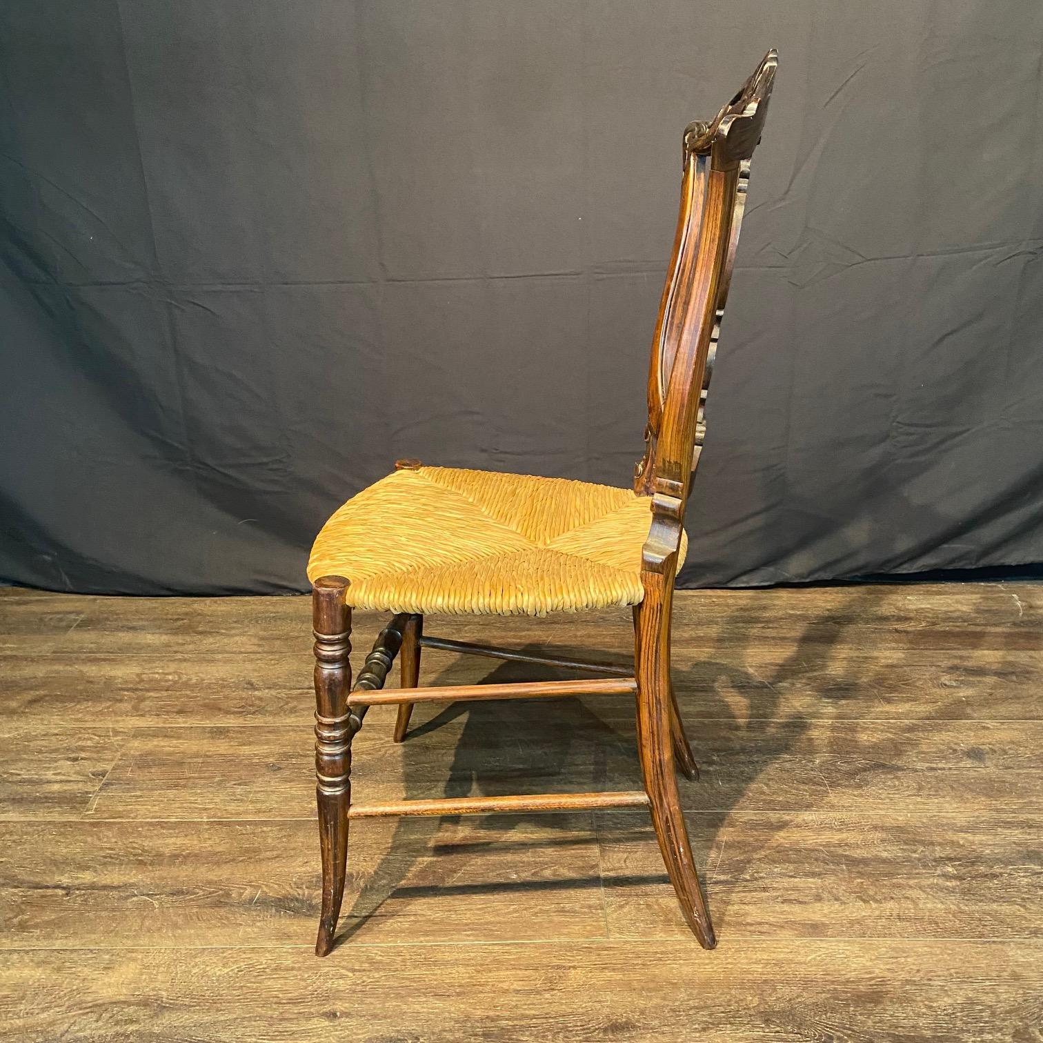 Grazioso esempio di elegante arte popolare dei primi anni dell'America, una poltrona o sedia d'accento impiallacciata in legno di palissandro con uno squisito schienale intagliato che mostra foglie d'acanto e una cresta floreale. Sedile Rush in