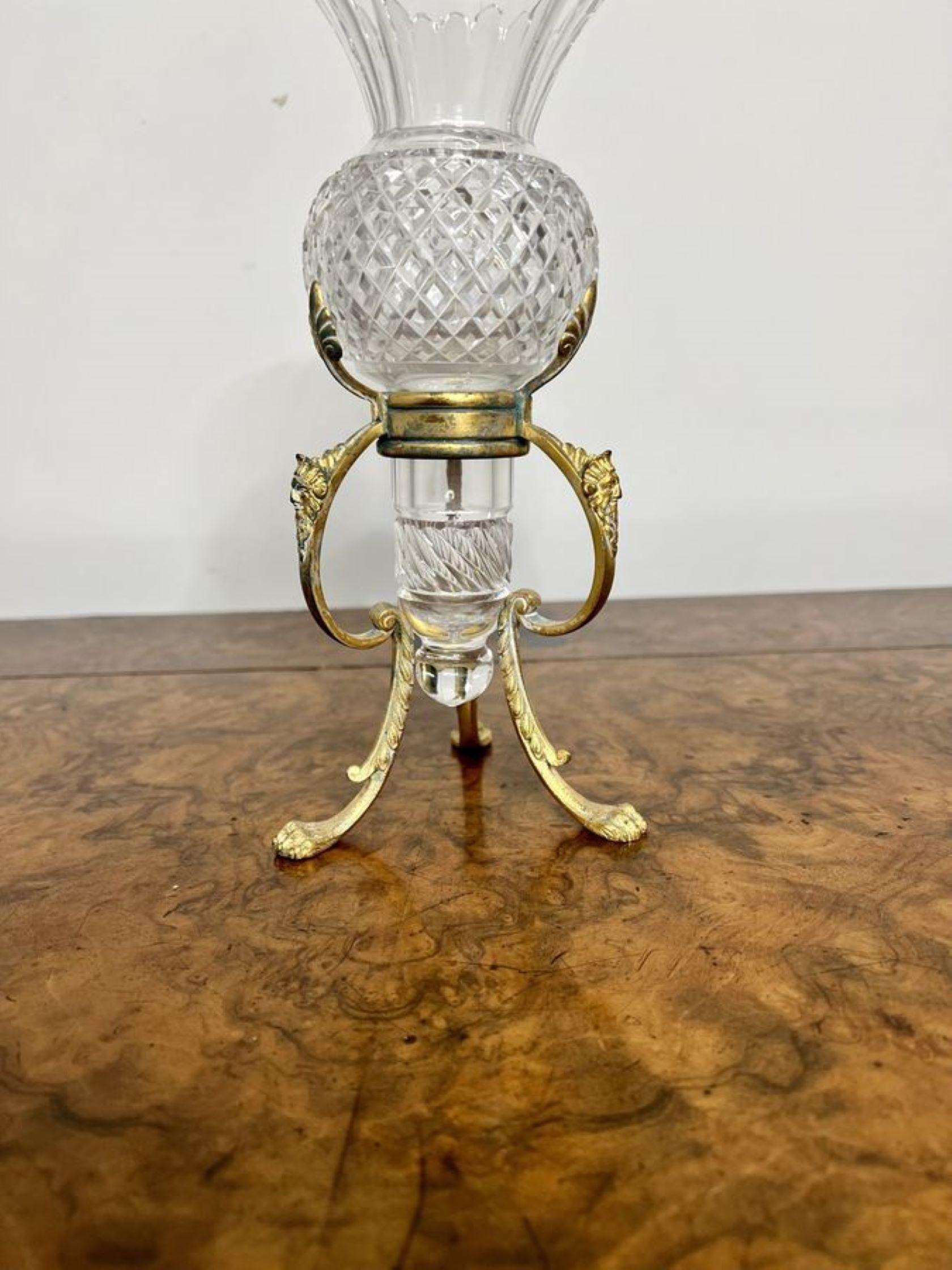 Lovely antique cut glass vase on an ornate stand having a quality cut glass removable vase with a fantastic fluted shaped top on a ornate metal stand raised on paw feet.

D. 1900