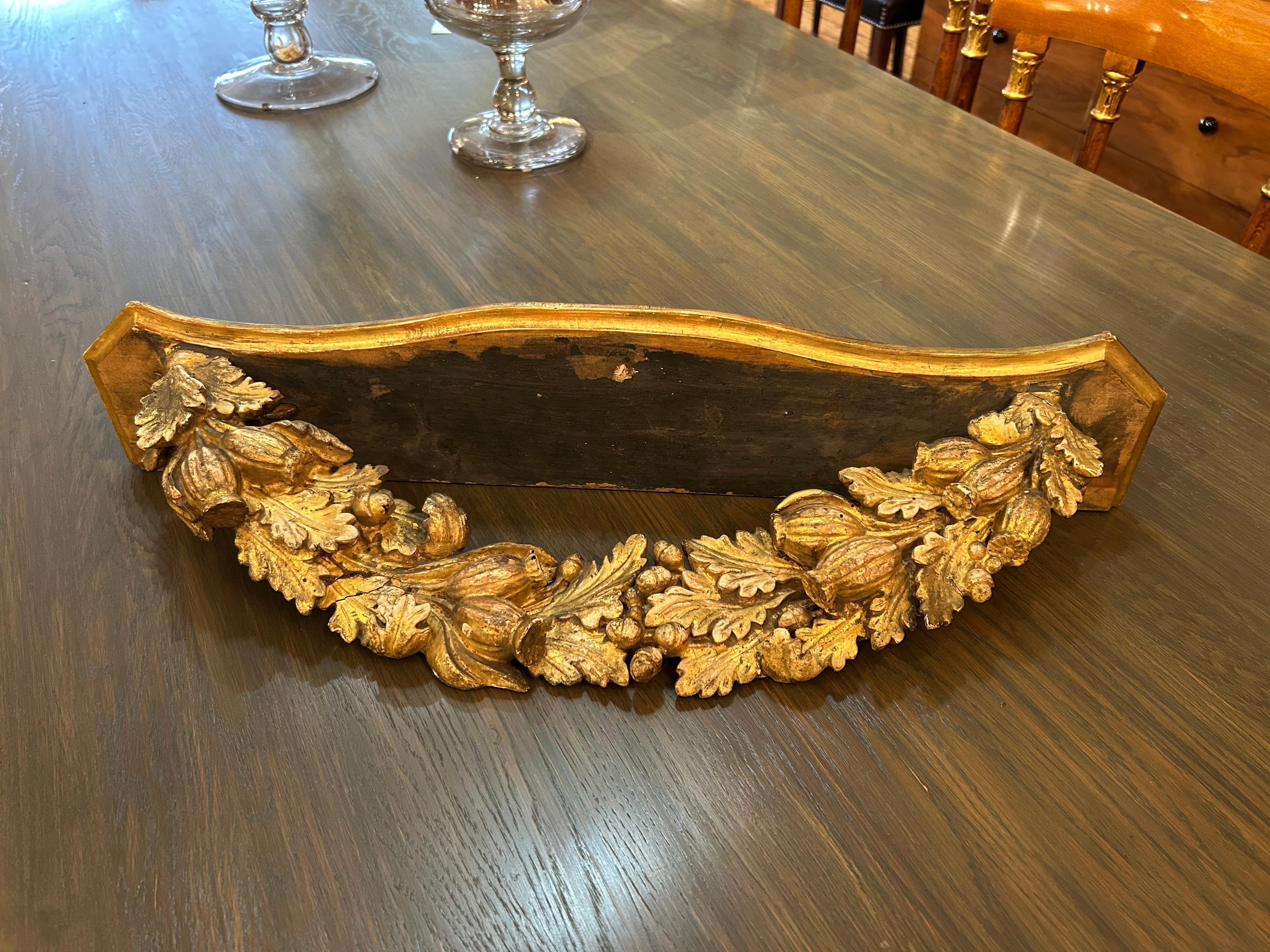Lovely rustic antique wall shelf having weathered giltwood carved swag adorning the bottom.