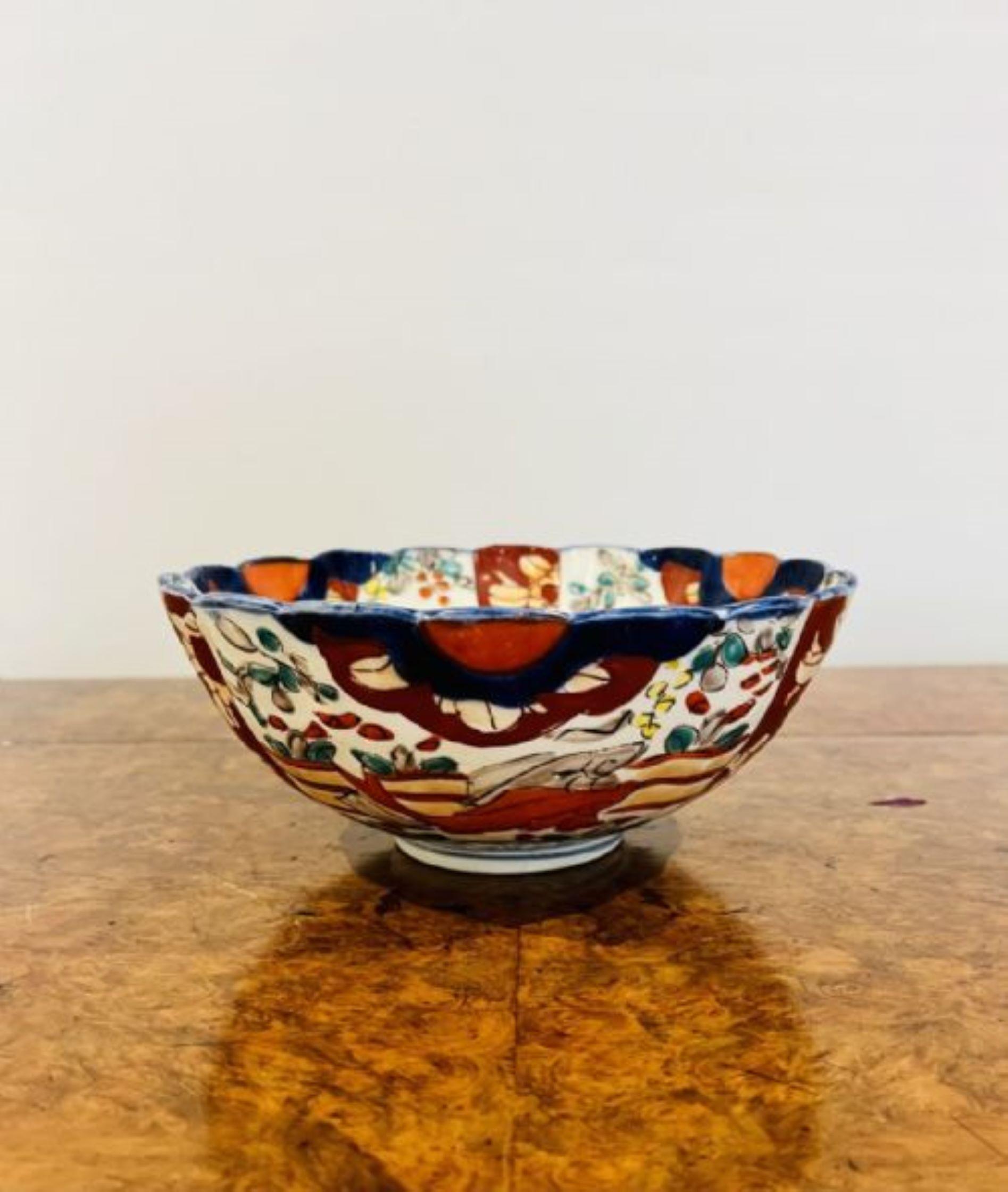 Lovely antique Japanese imari bowl with a scallop shaped edge having a lovely antique Japanese imari bowl with wonderful hand painted panels with leaves, trees, fish and flowers in wonderful red, blue, green and white colours. 