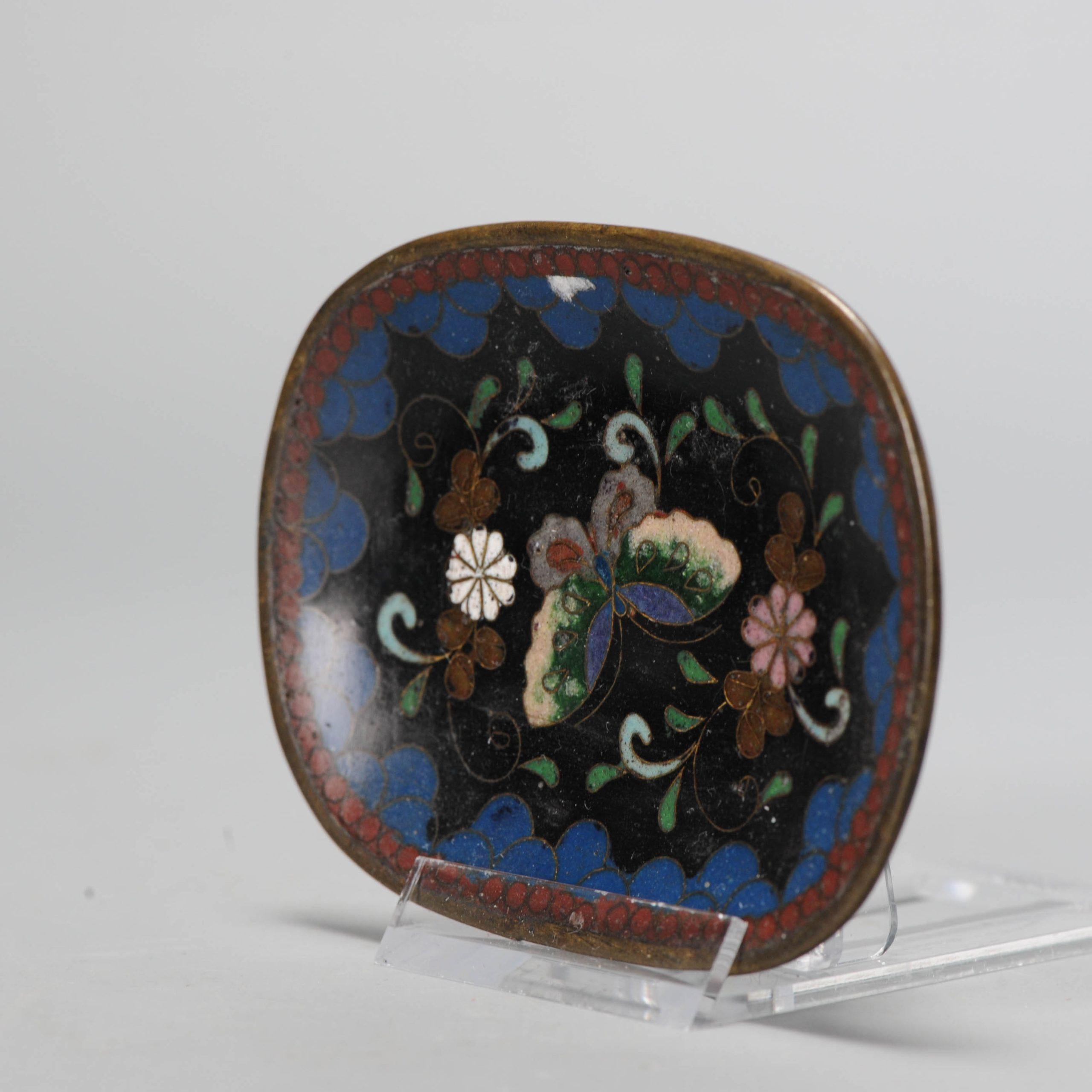 Lovely and beautifully made piece with flowers and butterfly.

Cloisonné is an enamelling technique in which the pattern is formed by wires soldered to the surface of the object to be decorated, which is usually made from copper, forming cells or