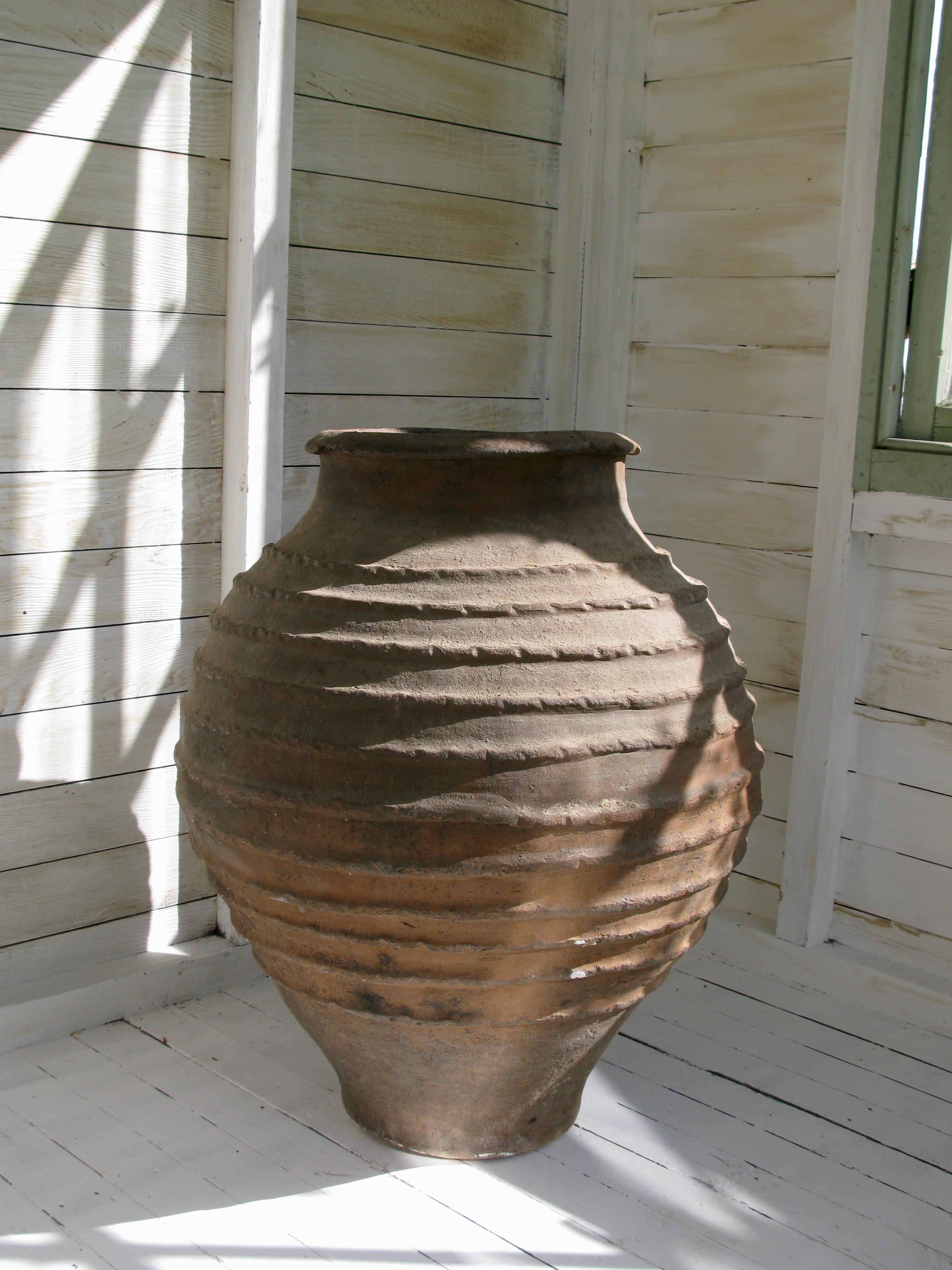 19th century Spanish antique ribbed olive pot of very good size, with lovely old patina. These ribbed pots are original from the Salamanca region. It has a beautiful natural weathered color with rings of terracotta clay and it has a round