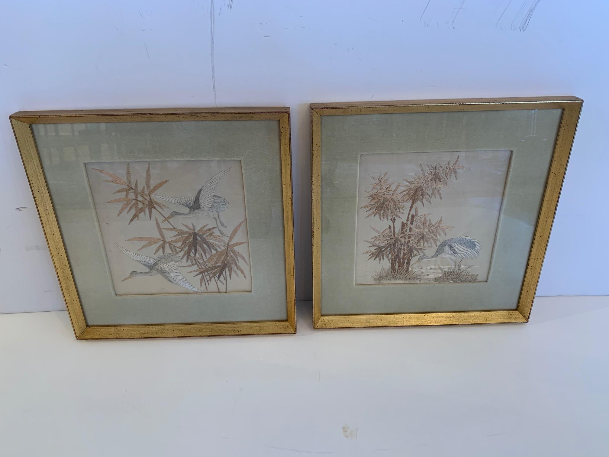 Lovely pair of fine silk needlework of herons and bamboo having subtle color palette of platinum grey, silver, white and champagne. Each is beautifully framed with celadon velvet mats and gilt moldings.