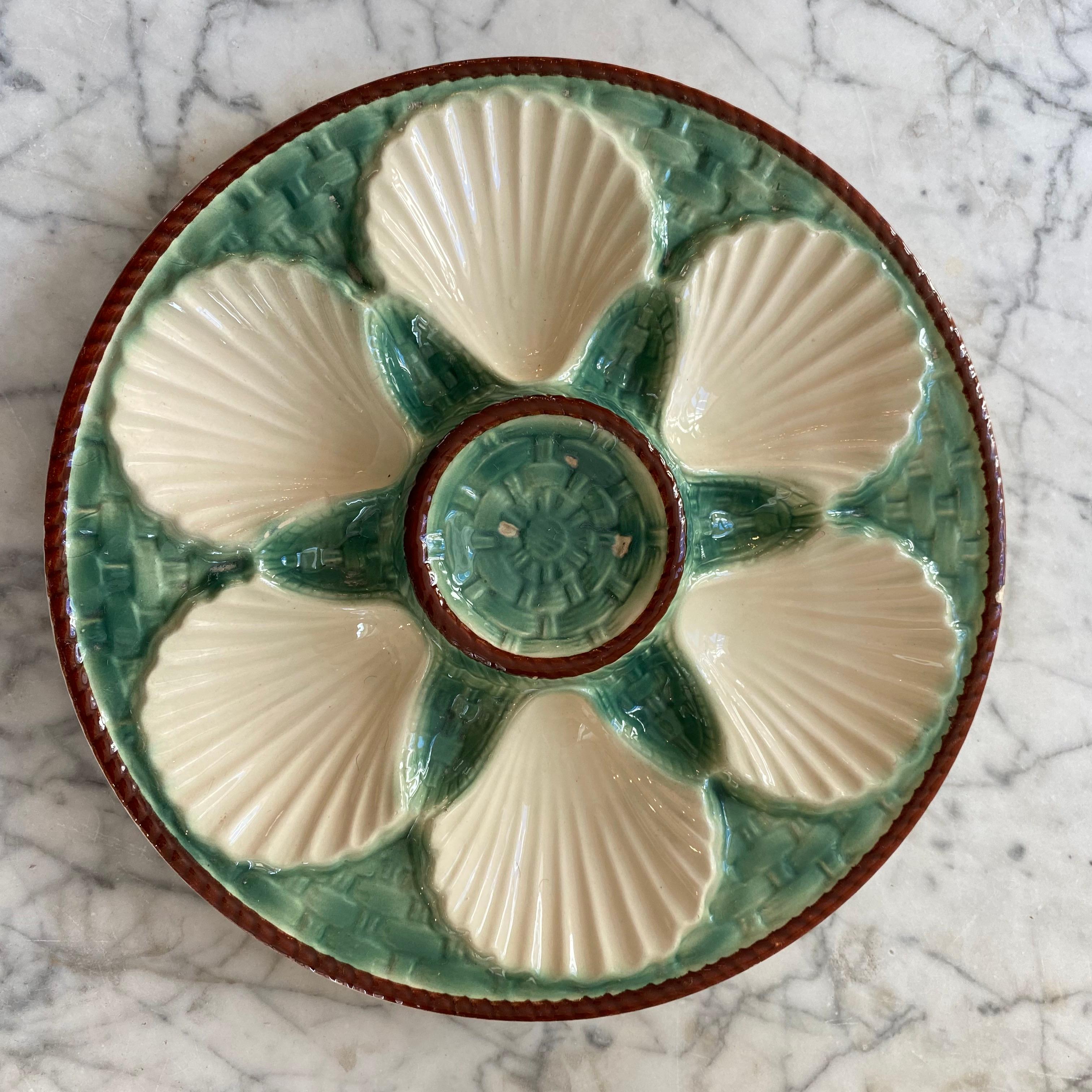 Lovely French Majolica oyster plates, circa 1890. Unsigned. Great detail and green and cream color pallet with brown trim.
