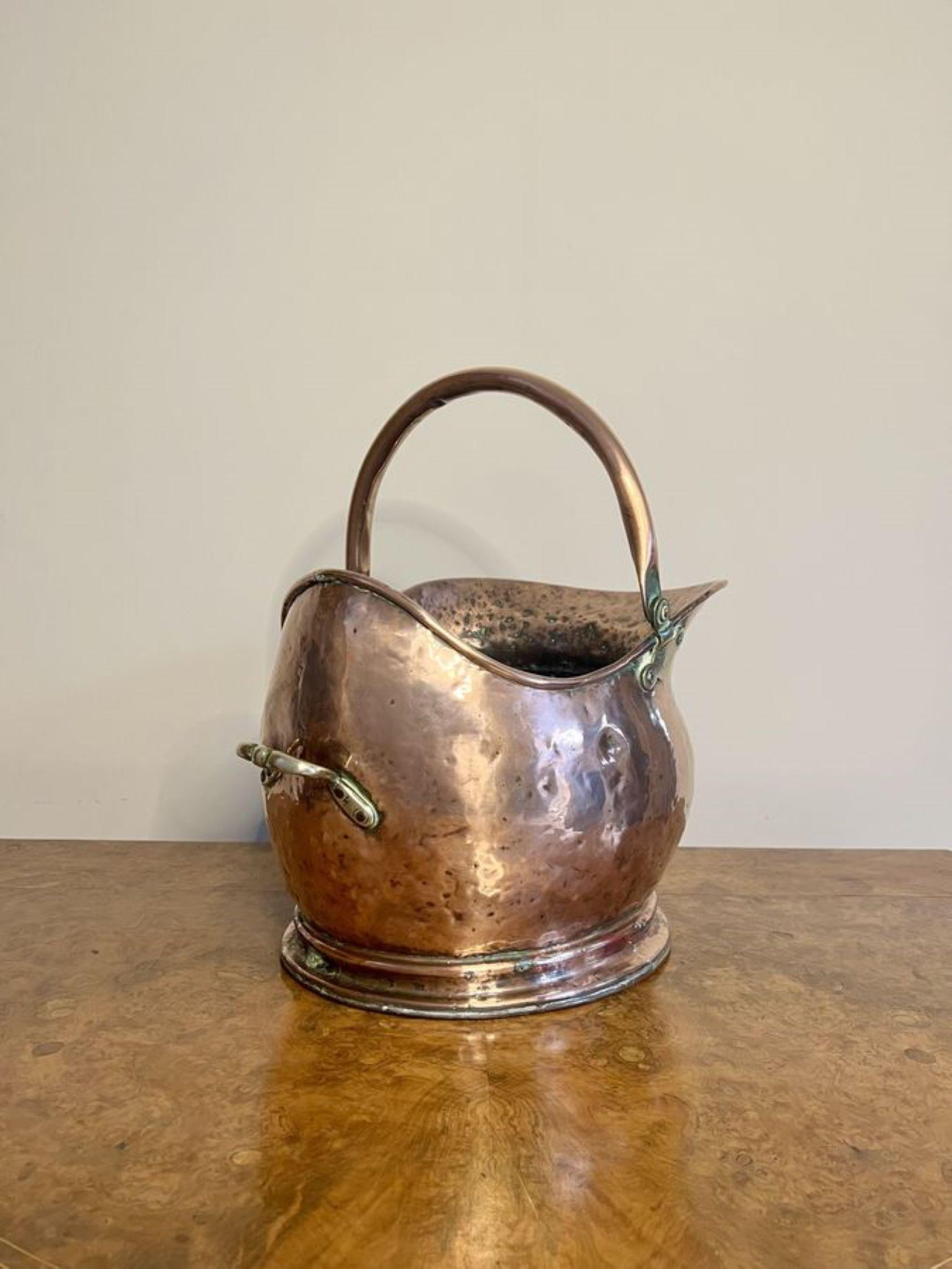 Lovely antique Victorian copper helmet coal scuttle having a copper swing carrying handle to the top with a shaped quality copper helmet coal scuttle and a brass carrying handle to the back.

D. 1880