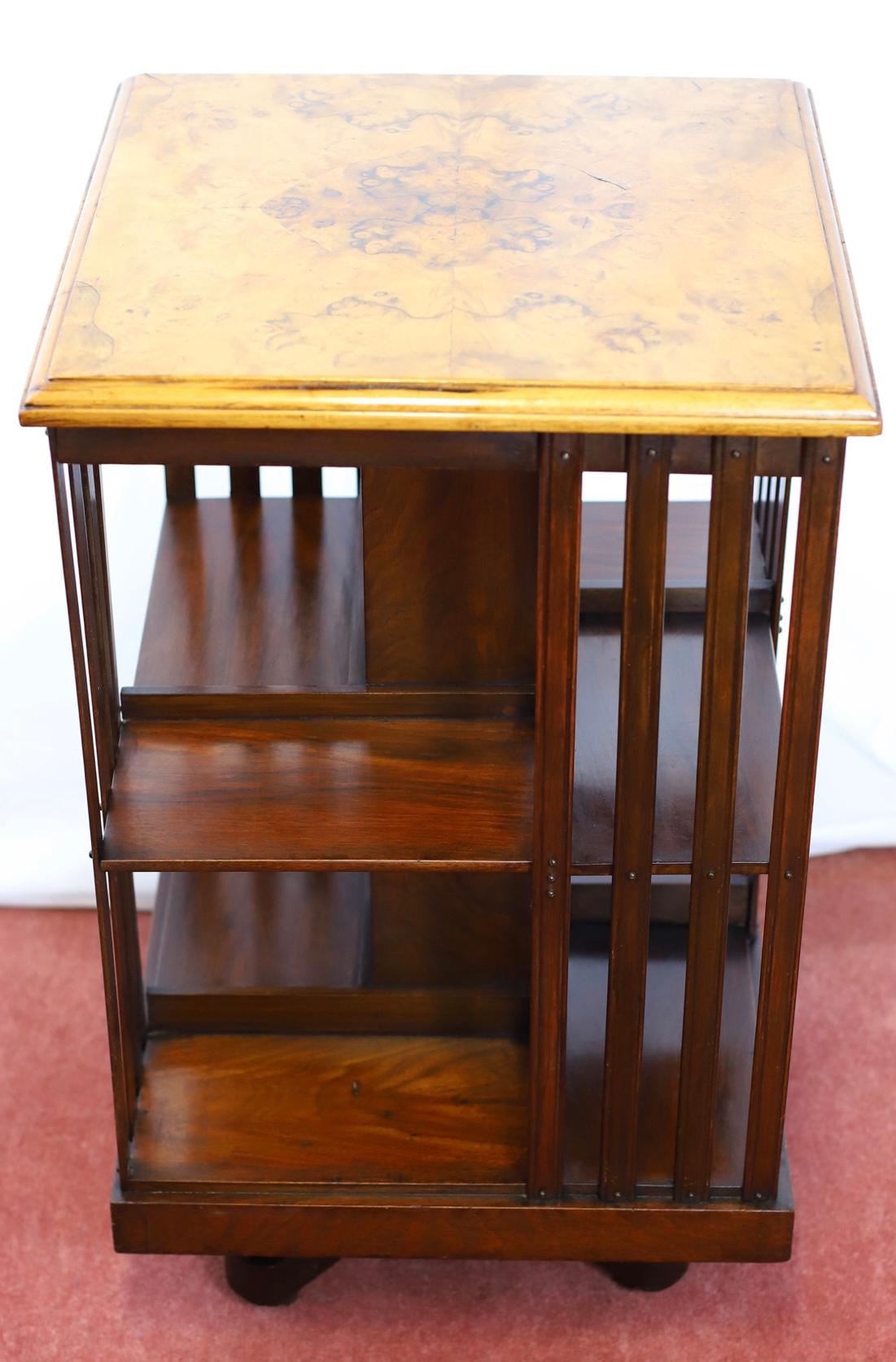 We delight to offer for sale this lovely antique 20th century revolving bookcase. The antique oak revolving bookcase has two tiers, consisting of eight various sized compartments. Raised on a quad form base with castors for easy movement. Well