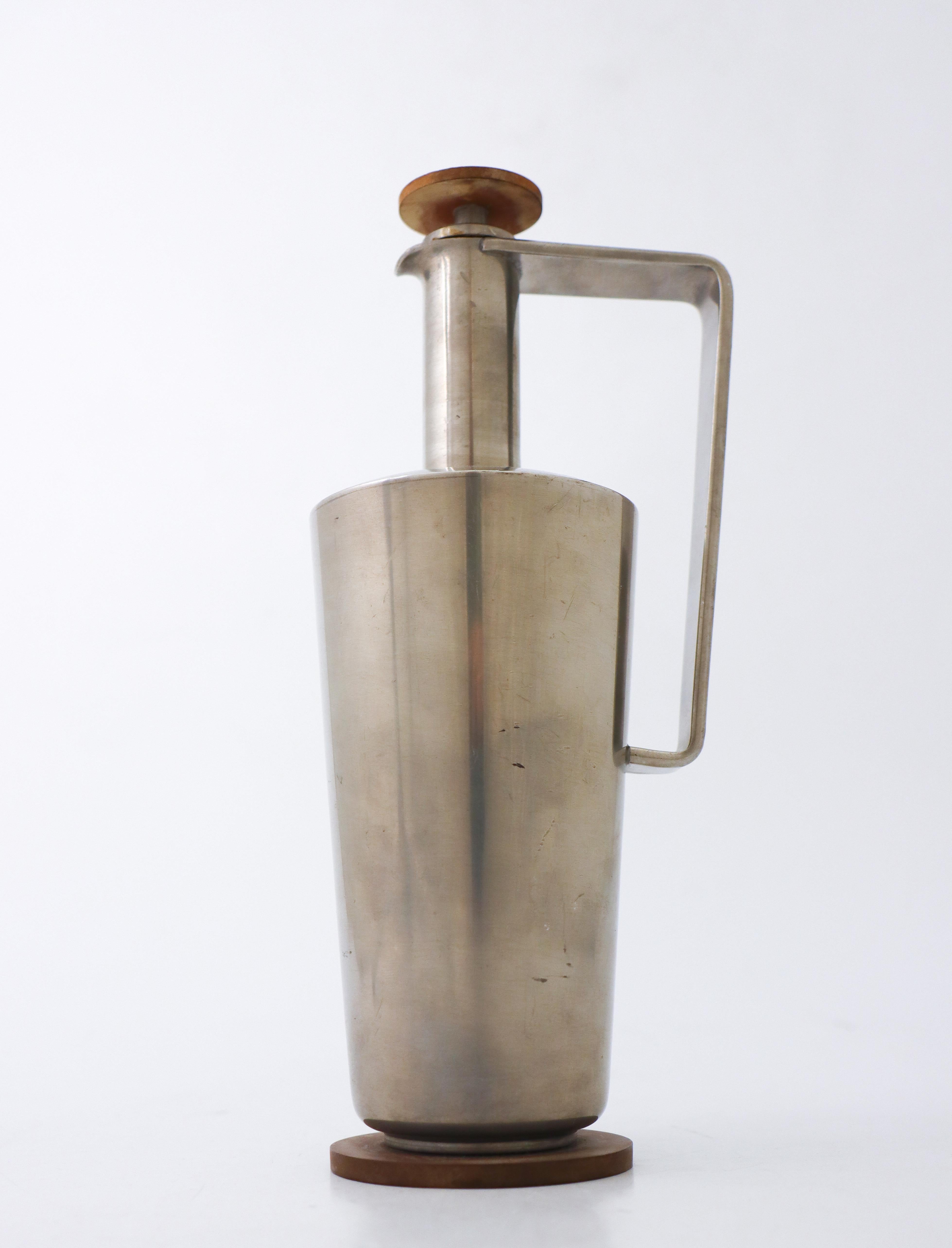 A beautiful bottle in metal in lovely art deco style designed by Carl-Einar Borgström at Ystad Metal in Sweden 1943. The stopper and the base is made of bakelite. It is 24 cm (9.6