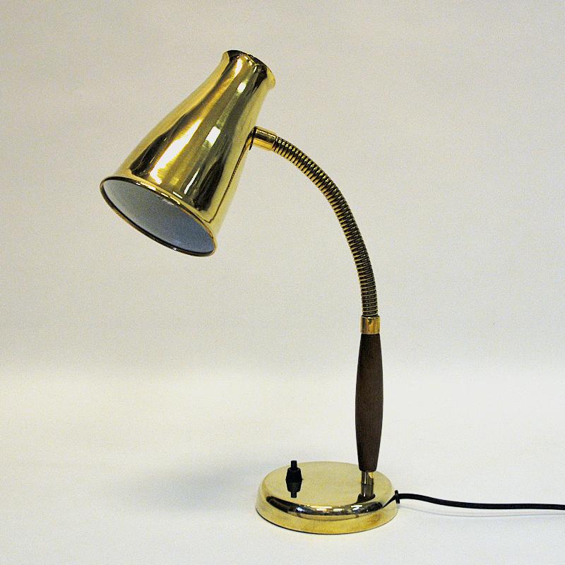 Lovely teak and brass table/desk lamp mod 5220 by Einar Bäckström, Sweden 1950s. Teak and brass pole, brass footbase with a light switch. Brass shade and body adjustable in all directions. Sculpted teak handle. Marked with model number and signature