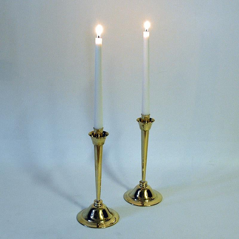 Lovely mid-century brass candlestick holders by Swedish designer Lars Holmström, Arvika, Sweden 1960s. The candleholders are both beautiful, classic, unique and takes is stunning on the table, window or island. Marked underneath with label Lars