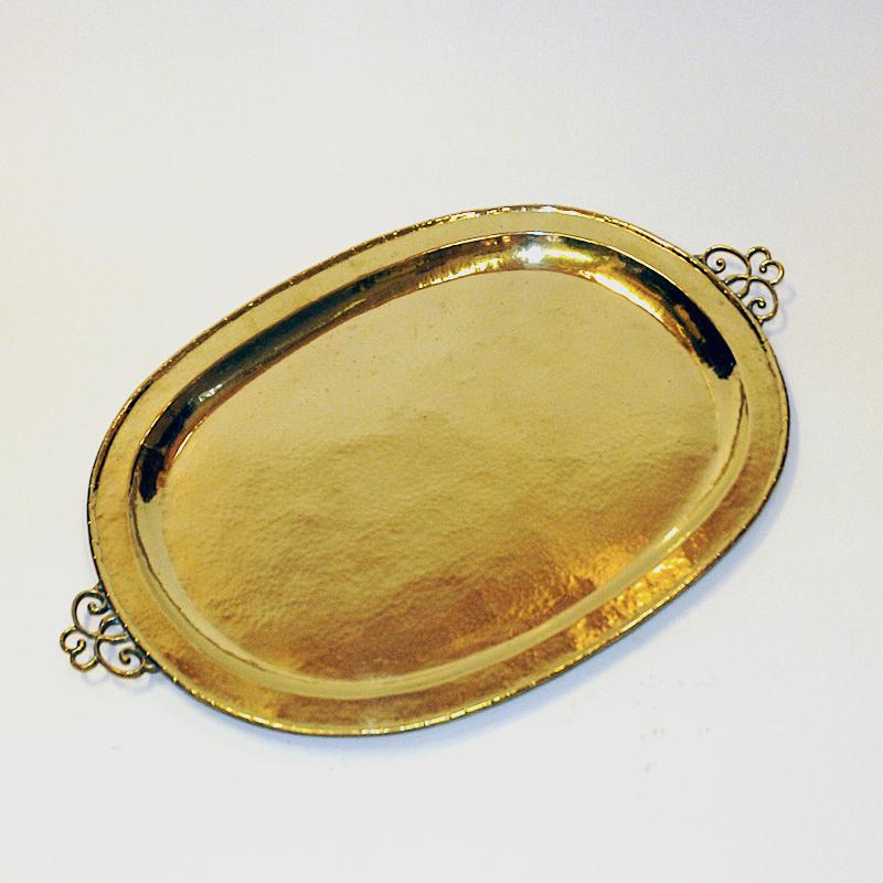 Lovely vintage oval brass serving or decor tray made by E. Erickson, Sweden 1930s. The plate is made of handhammered solid brass and has a brass frame all around with decorative handles on the the sides. Perfect for serving purpose or even as