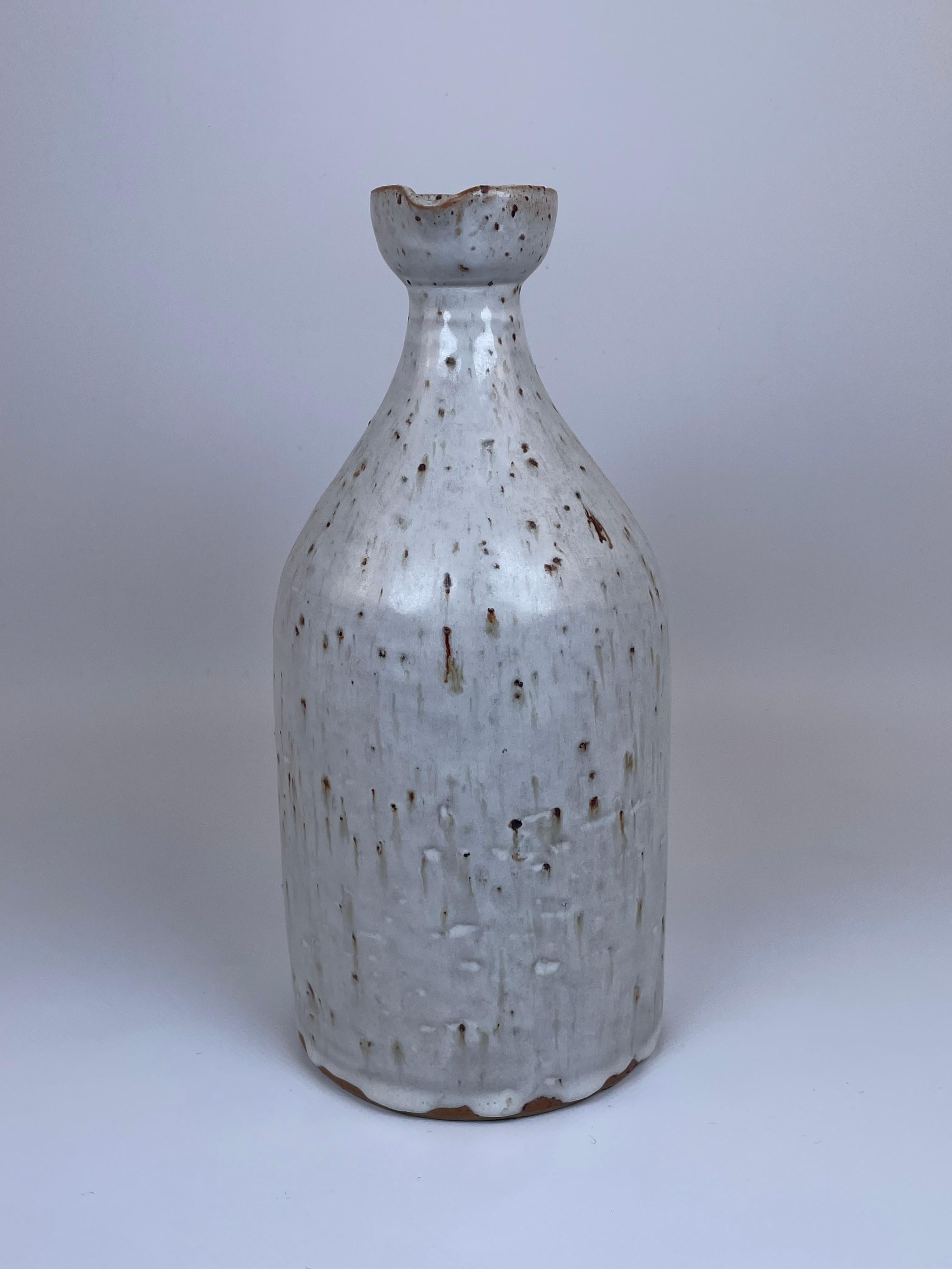 Questa brocca in ceramica, attribuita a Robert Picault, esemplifica la sua maestria nel design funzionale e nel fascino rustico. La forma è elegante ma robusta, con un corpo arrotondato, un collo stretto e un manico graziosamente curvo. Lo smalto