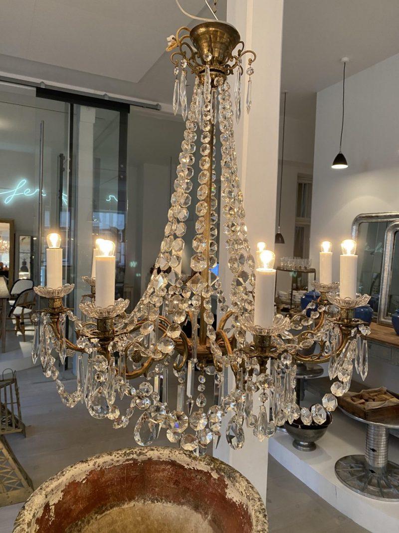 Lovely old French chandelier, circa 1920-1940s.

This piece has a brass frame, and 8 light pipes for electricity, with charming glass light cuffs.

Note the beautiful beading, and countless faceted prisms that cast the light so well.