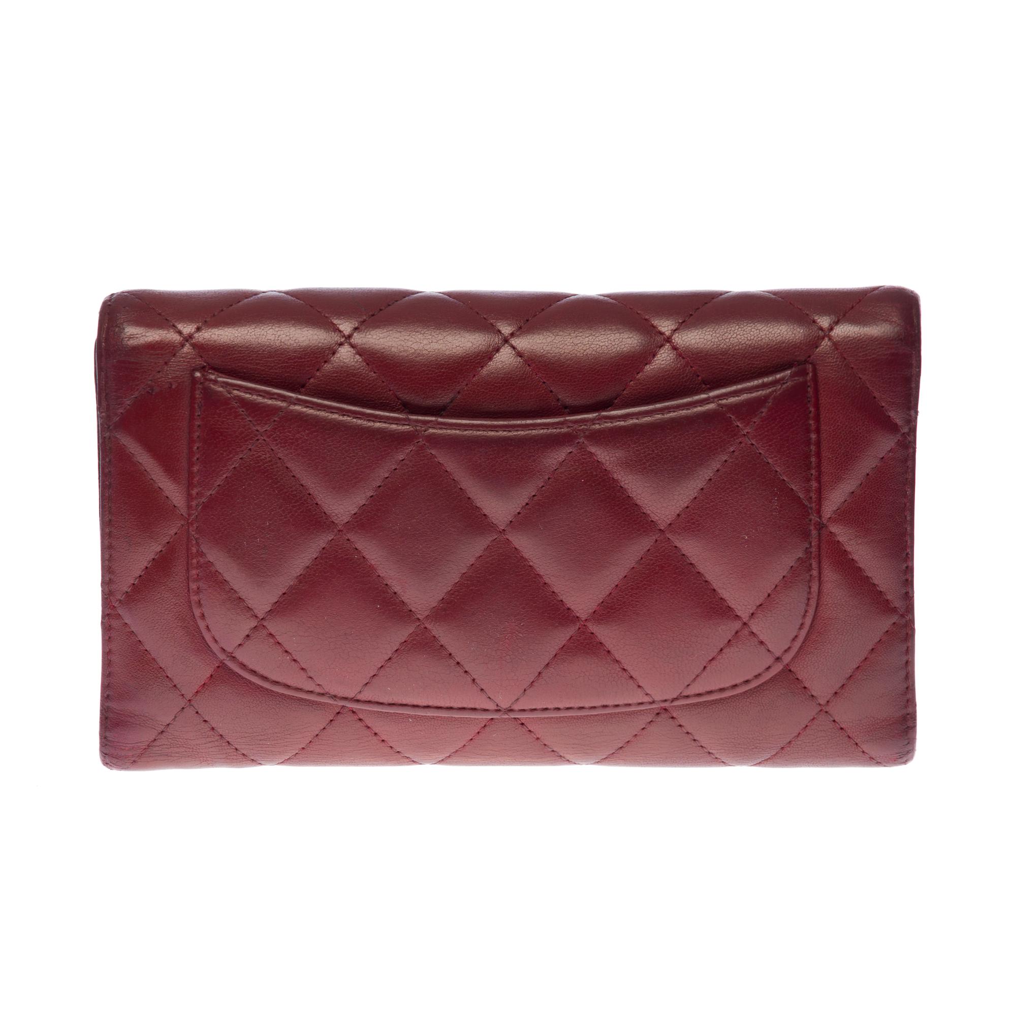 Lovely​ ​Chanel​ ​flap​ ​wallet​ ​in​ ​quilted​ ​burgundy​ ​lambskin​ ​leather,​ ​with​ ​silver-tone​ ​metal​ ​hardware​ ​allowing​ ​for​ ​handheld​ ​carry

One​ ​flat​ ​pocket​ ​at​ ​the​ ​back​ ​of​ ​the​ ​bag.​ ​Snap​ ​button​ ​closure,​ ​silver​