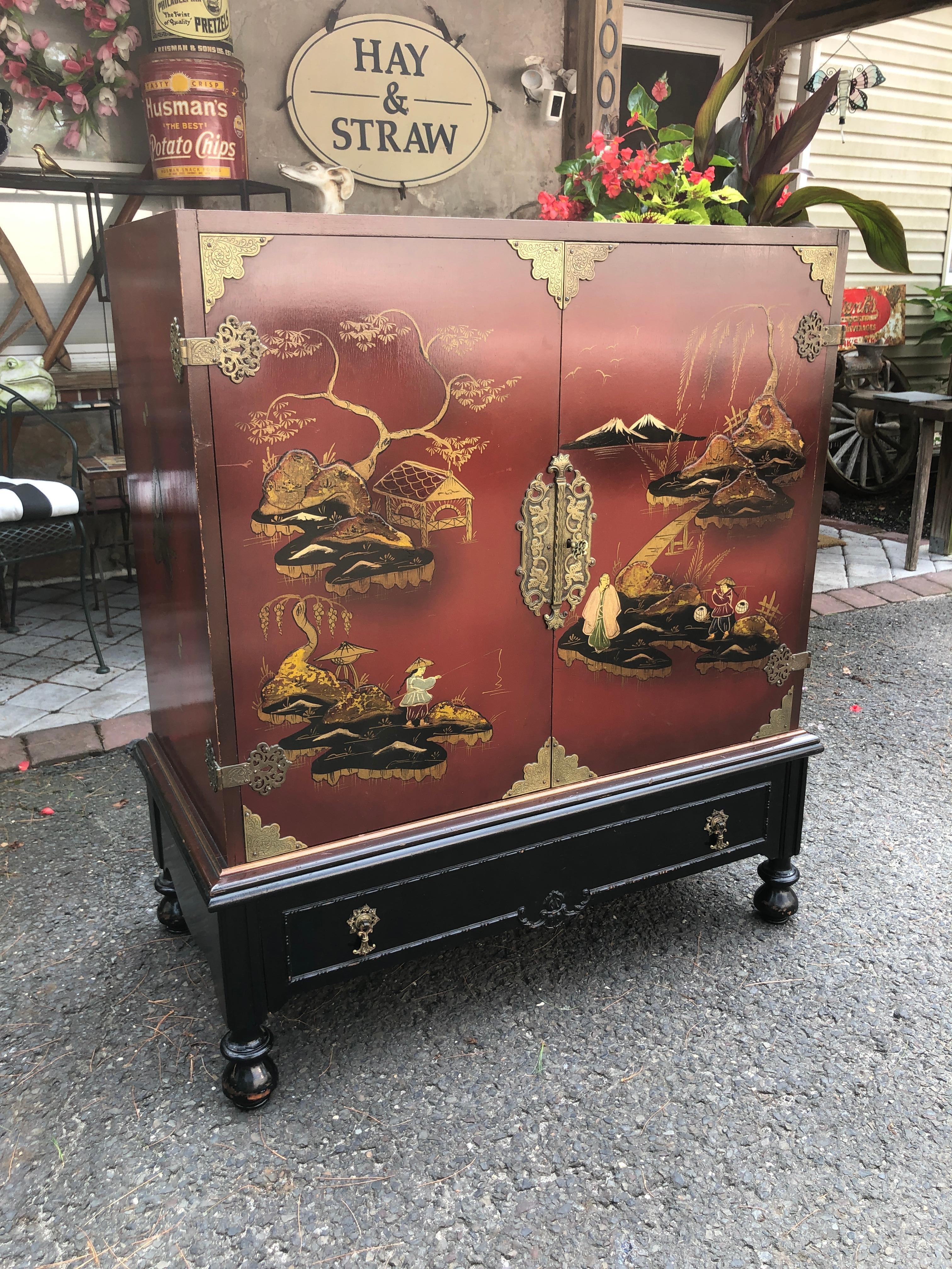 Fabulous Chinoiserie hand painted linen chest or bar cabinet. We love the deep red lacquer finish with the hand painted landscape scenery. We also love the pierced solid brass hardware along with the original fancy key. The inside has 2 adjustable