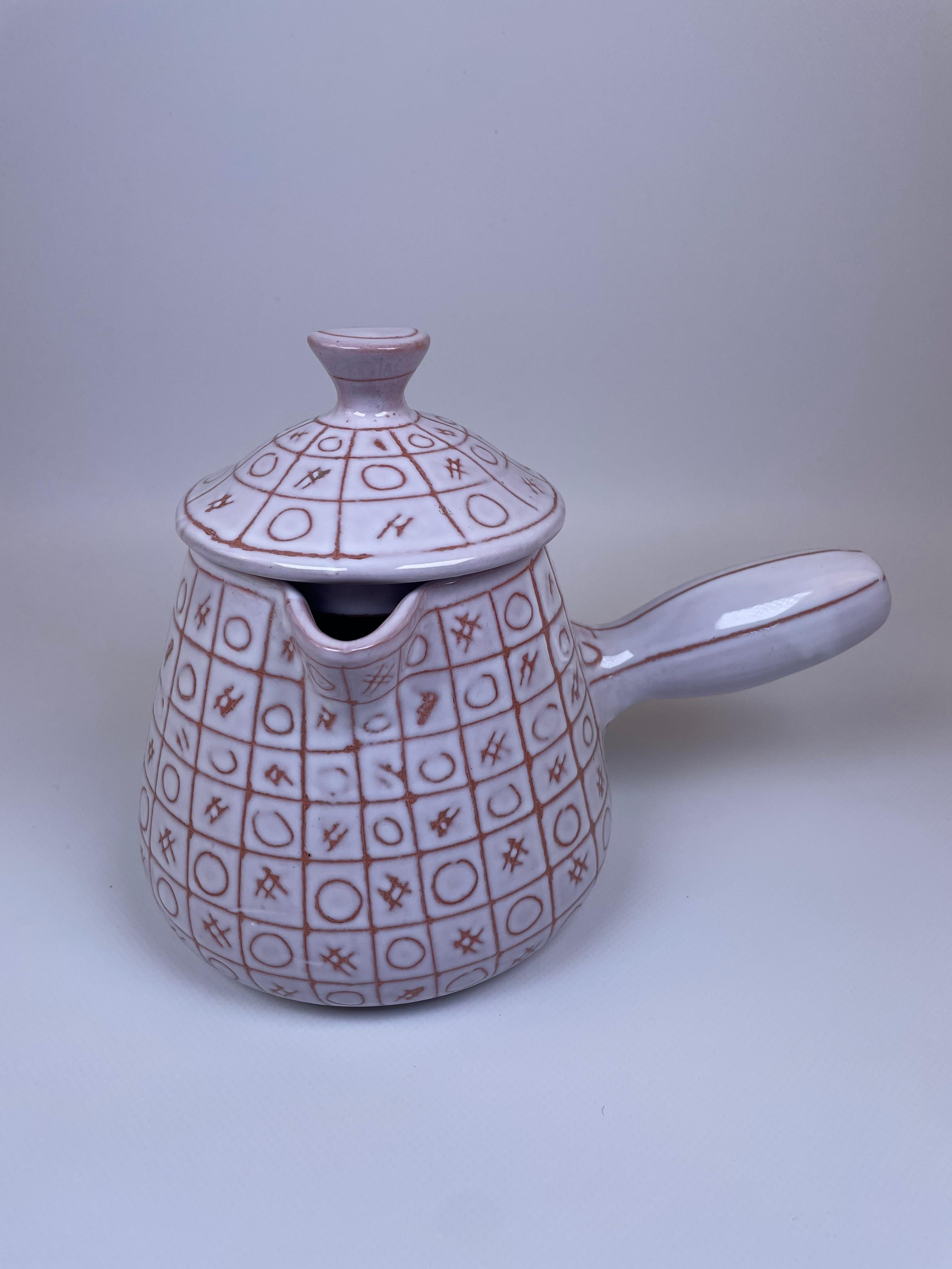 Il s'agit d'une chocolatière en céramique fabriquée par Robert Picault à Vallauris dans les années 1950. Connue pour ses designs distinctifs, cette pièce présente le quadrillage caractéristique de Picault avec des motifs géométriques, peints à la