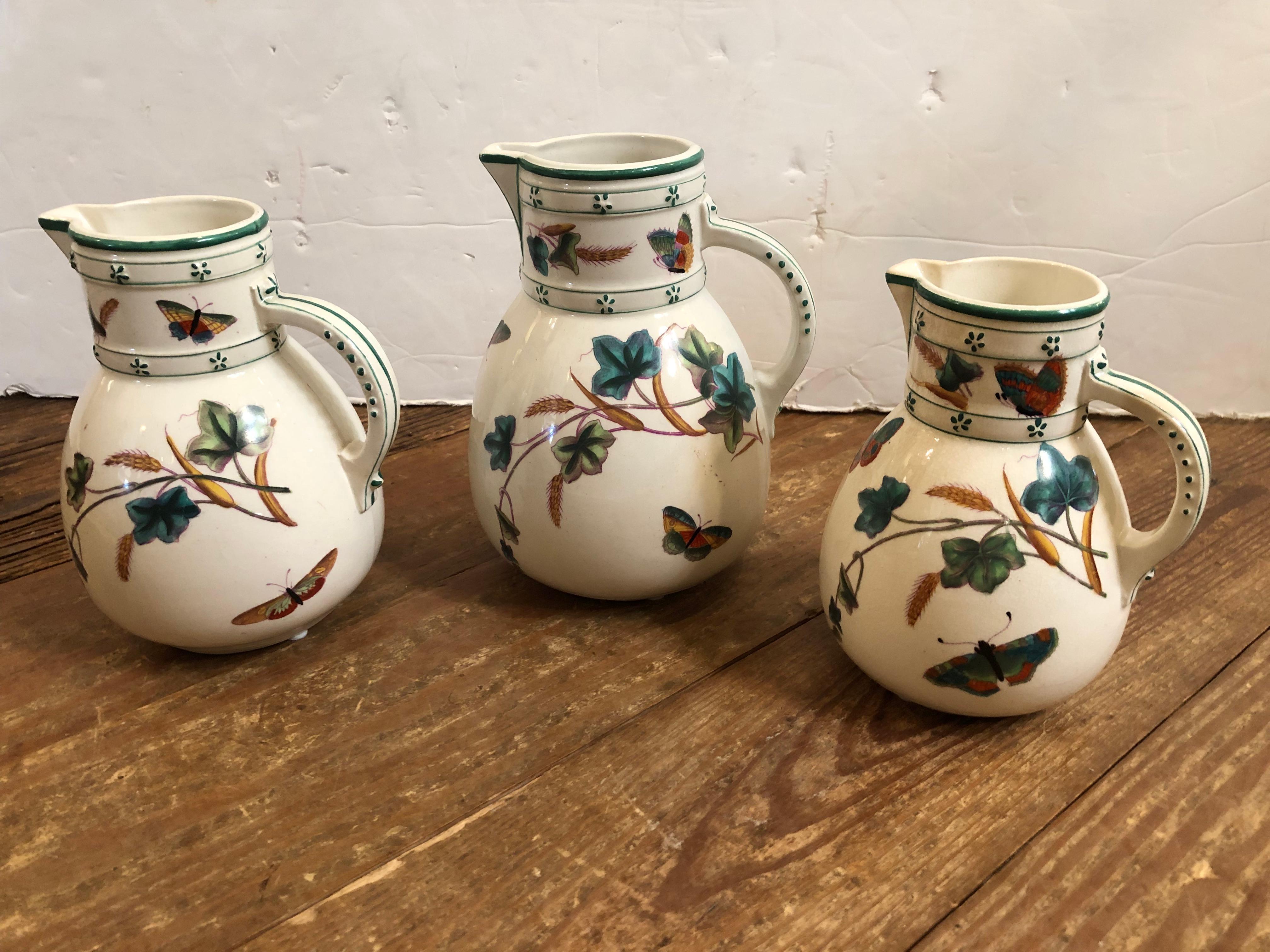 Lovely collection of 3 antique English porcelain pitchers in varying sizes having gorgeous butterflies and flowers handpainted against a white background.
7.5