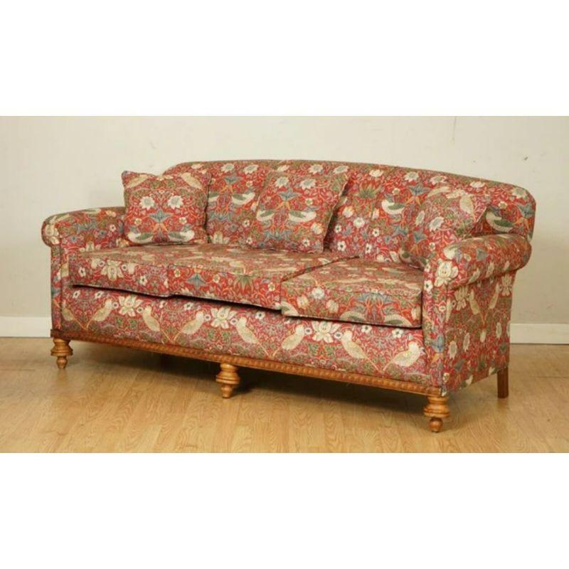 Wir freuen uns, dieses atemberaubende Vintage-Sofa mit William Morris-Stoff zum Verkauf anzubieten.

Dieses Sofa hat einen schönen geschnitzten Streifen aus Holz entlang der Vorderseite der Couch, mit passenden gedrehten Füßen. Das Sofa wurde mit