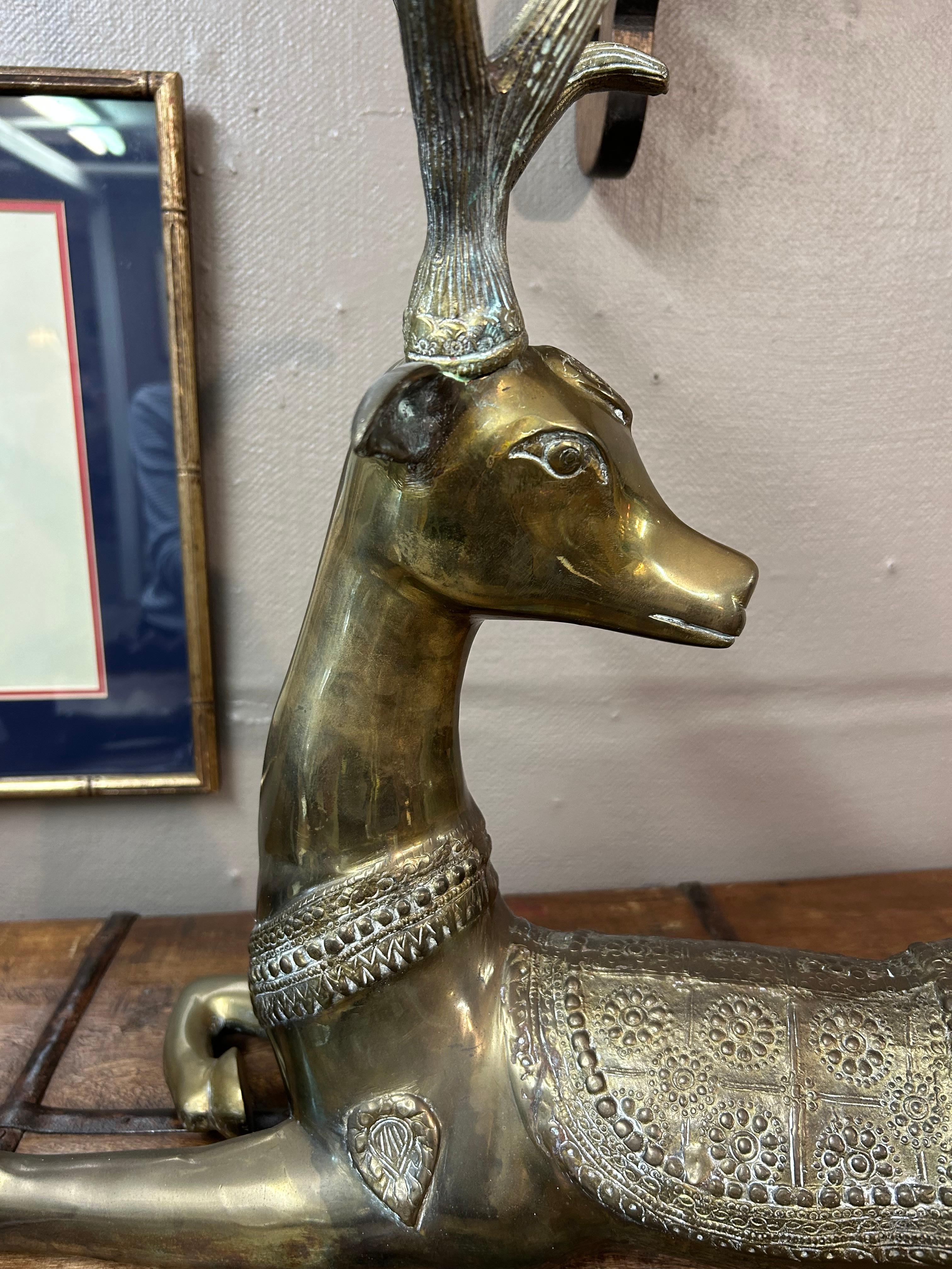 Lovely heavy cast brass sculpture of a recumbent deer having meticulous detailing and beautiful pose with one leg tucked underneath.