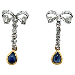 Ravissantes boucles d'oreilles à nœud en or jaune et platine avec diamants et saphirs