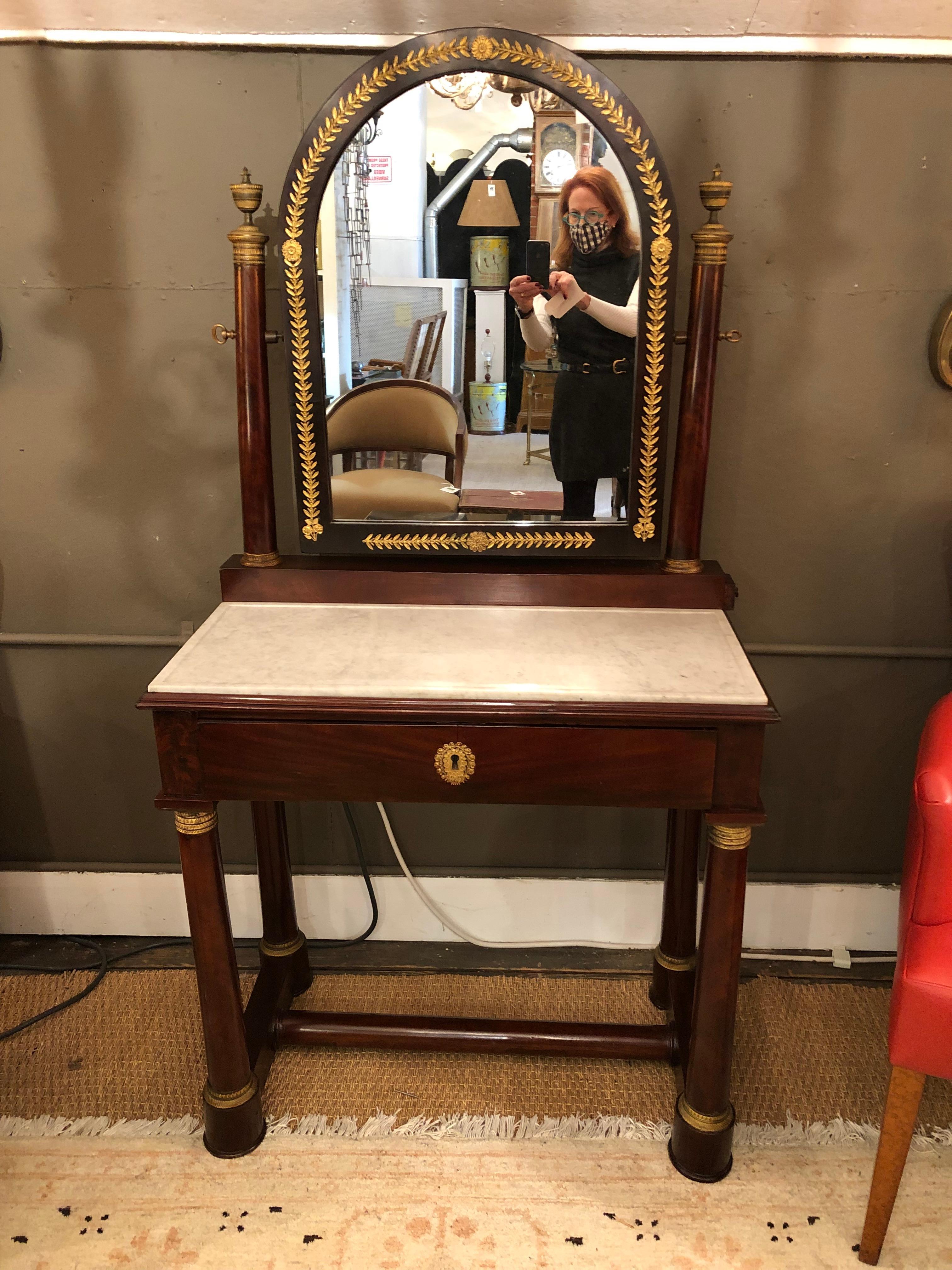 Elegant mahogany Federal style antique vanity table having gorgeous bronze details and white marble top. There's a single drawer and two mini side drawers.
Original key included.
Measure: Table height 30.5.