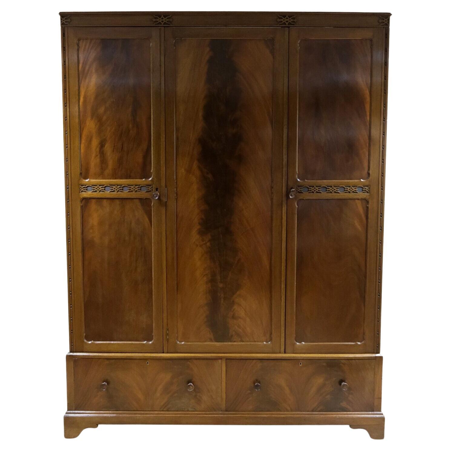 We are delighted to offer for sale this gorgeous flame Mahogany Vintage triple wardrobe with a mirror and a pair of drawers. 

This lovely triple wardrobe offers you plenty of storage. Behind the double and single doors, there is a good length,