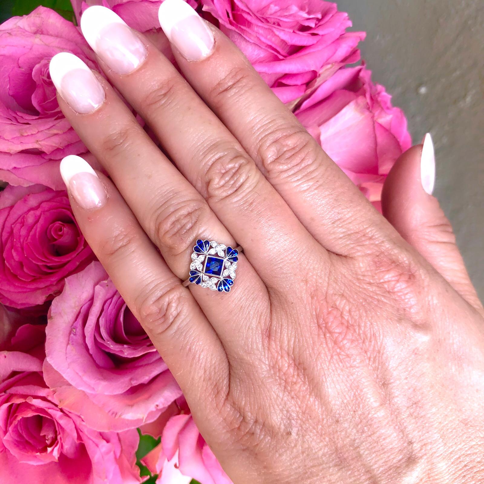 Sweet and sophisticated. Harking back to the 1920's, the platinum ring features a square-cut sapphire, with floret accents of 20 round brilliant-cut diamonds, and calibre-cut buff-top sapphire leaves. The sapphires weigh 1.07ct, with 0.12ct. of
