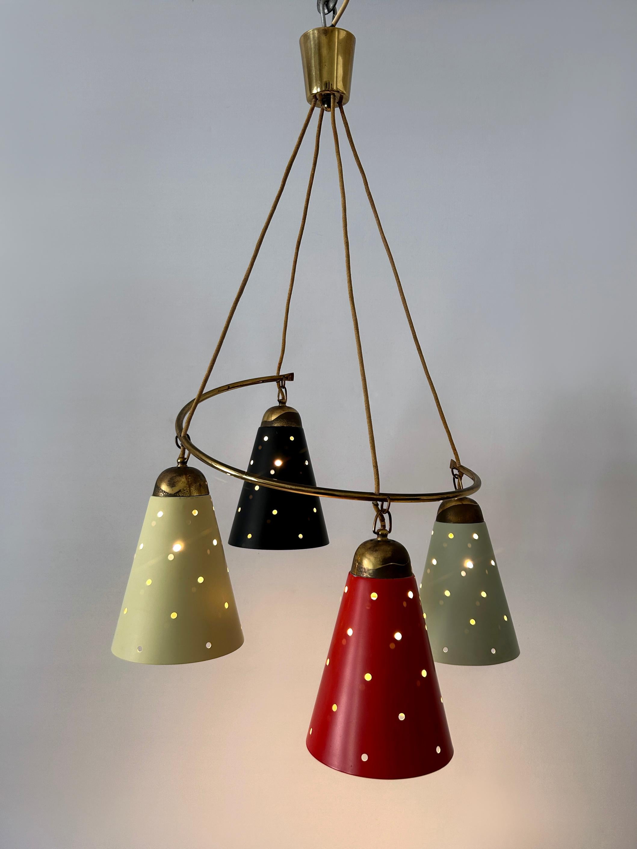 Extremely rare, lovely and highly decorative Mid-Century Modern four-armed Mid-Century Modern pendant lamp or chandelier. Designed and manufactured in Germany, 1950s.

Executed in brass and perforated aluminum, the pendant lamp / chandelier comes