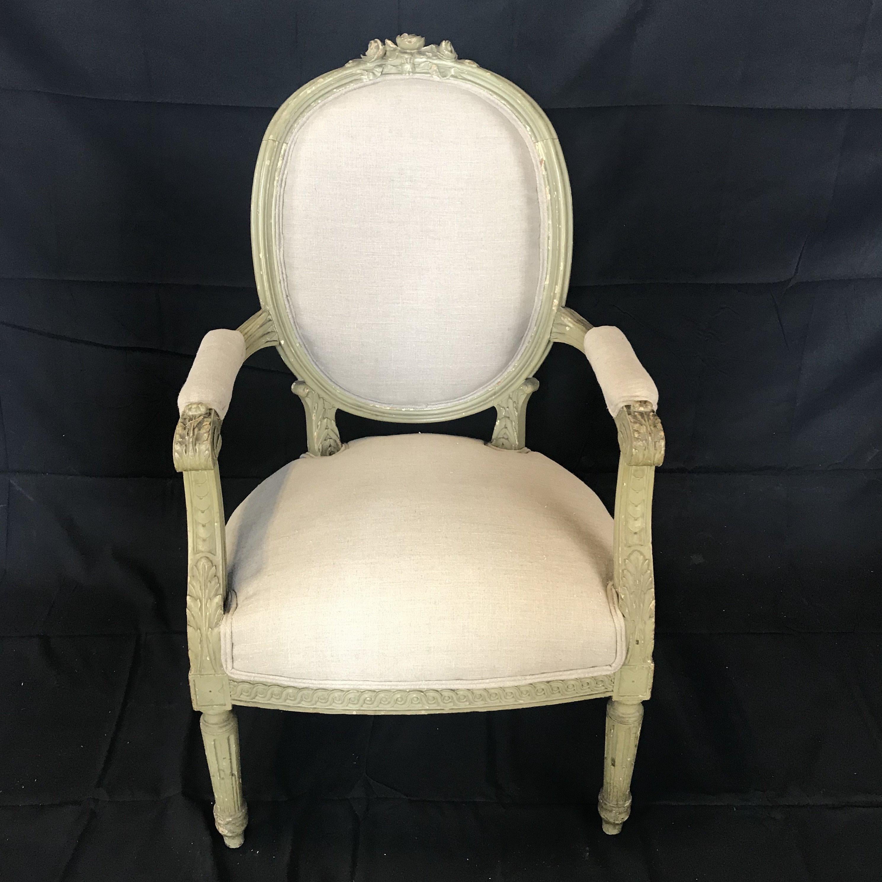 A very pretty late 19th century three piece Louis XVI style parlor set consisting of a settee and a pair of arm chairs having beautiful carved designs on the painted arms and legs and Classic oval backs. Newly reupholstered in a French linen cotton