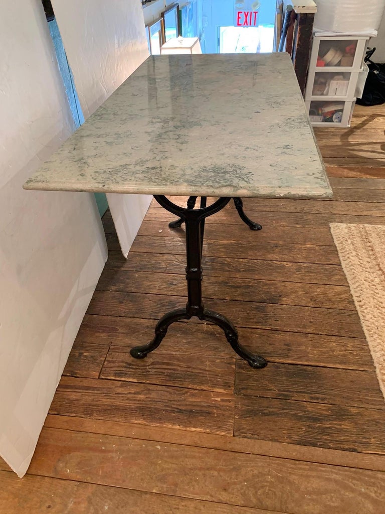 Versatile French marble top rectangular cafe table or writing desk having black iron base.