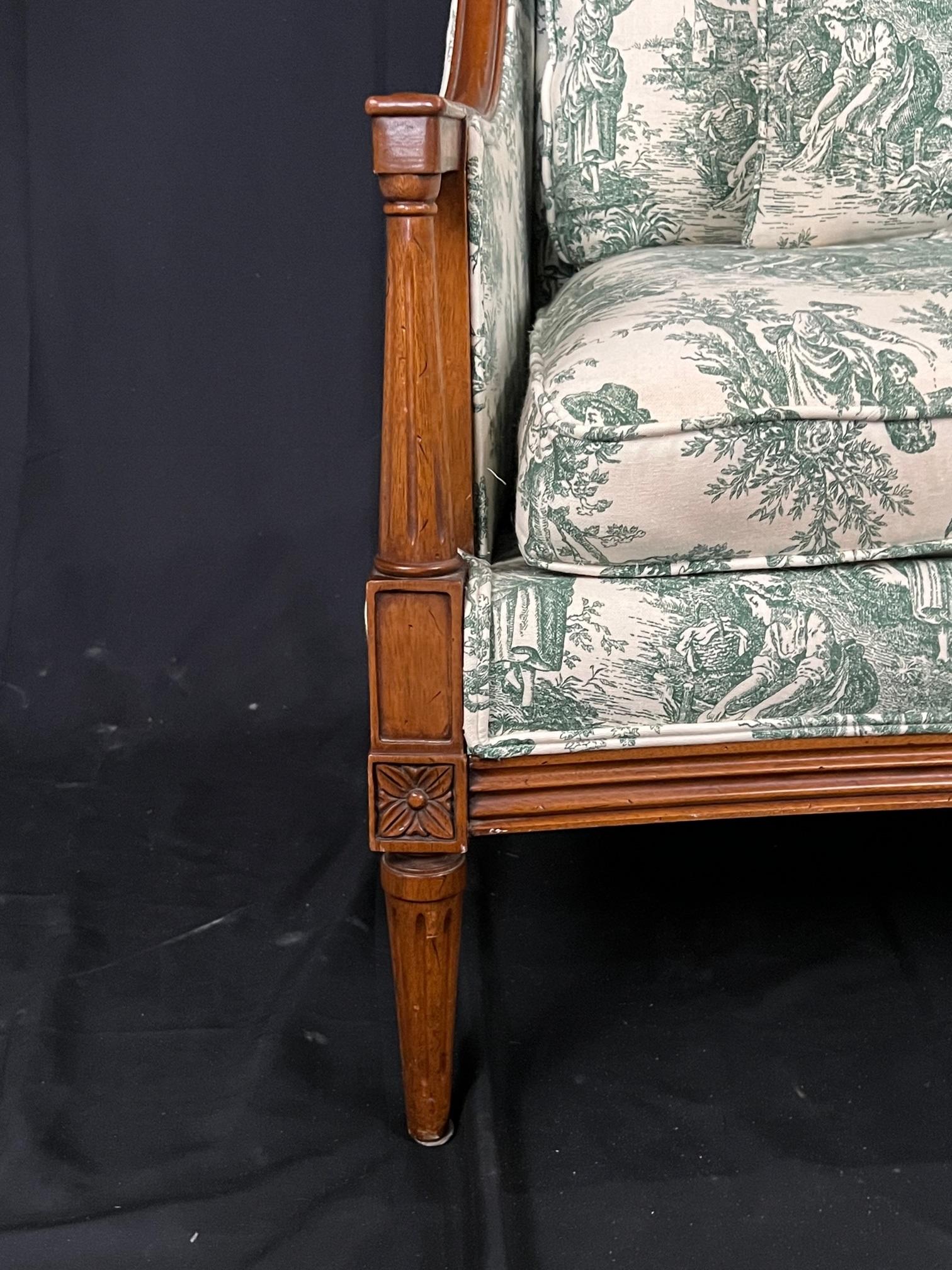Newly upholstered mid 20th century Louis XVI style carved walnut sofa with columnal legs and ornamental details in corners. Single welting and down wrapped seat. Age appropriate patina to wood throughout, and a cushion clip under seat. Lovely green
