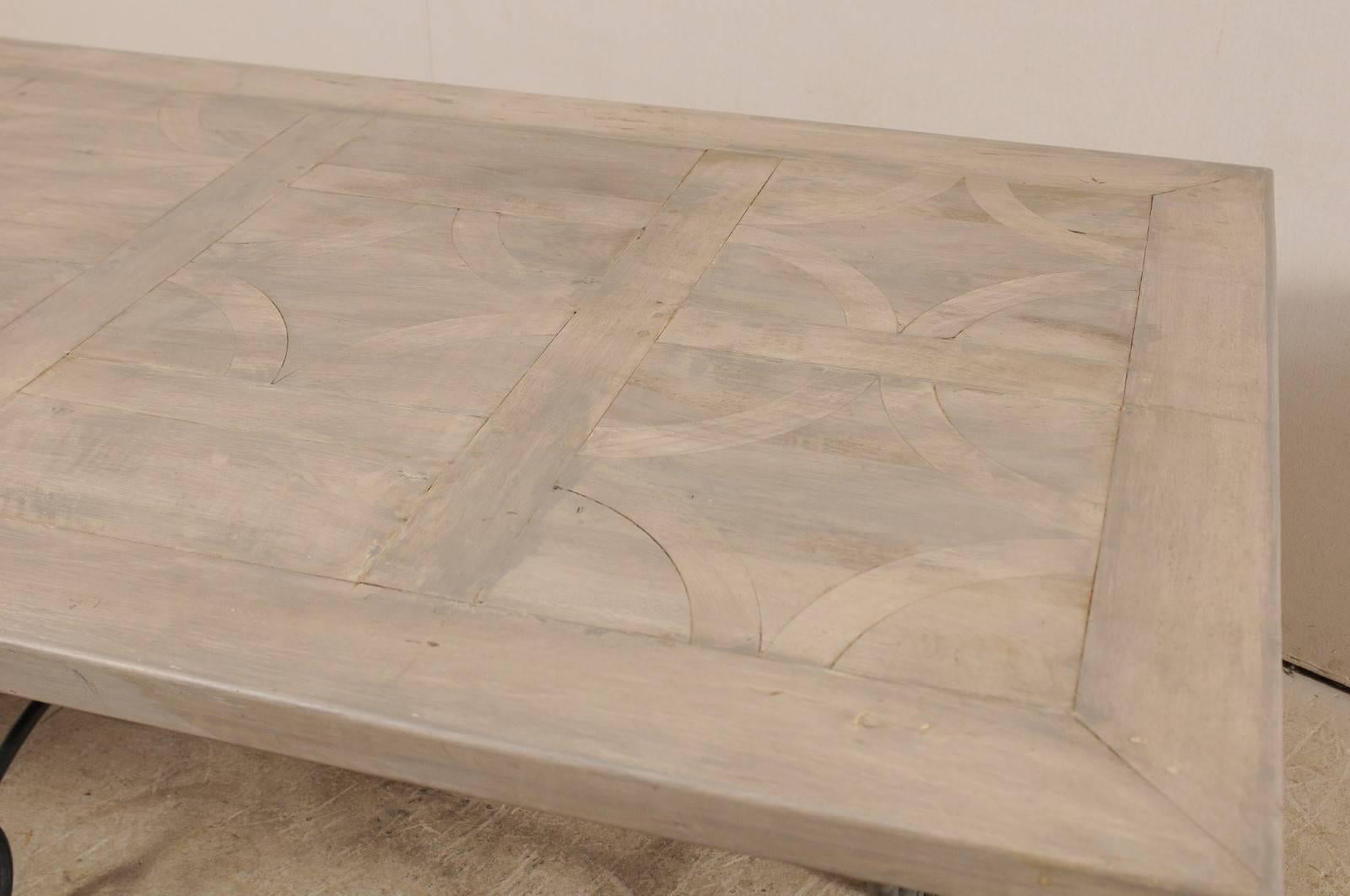 Mesa francesa de época con tablero de madera con incrustaciones sobre una hermosa base de hierro con volutas en venta 1