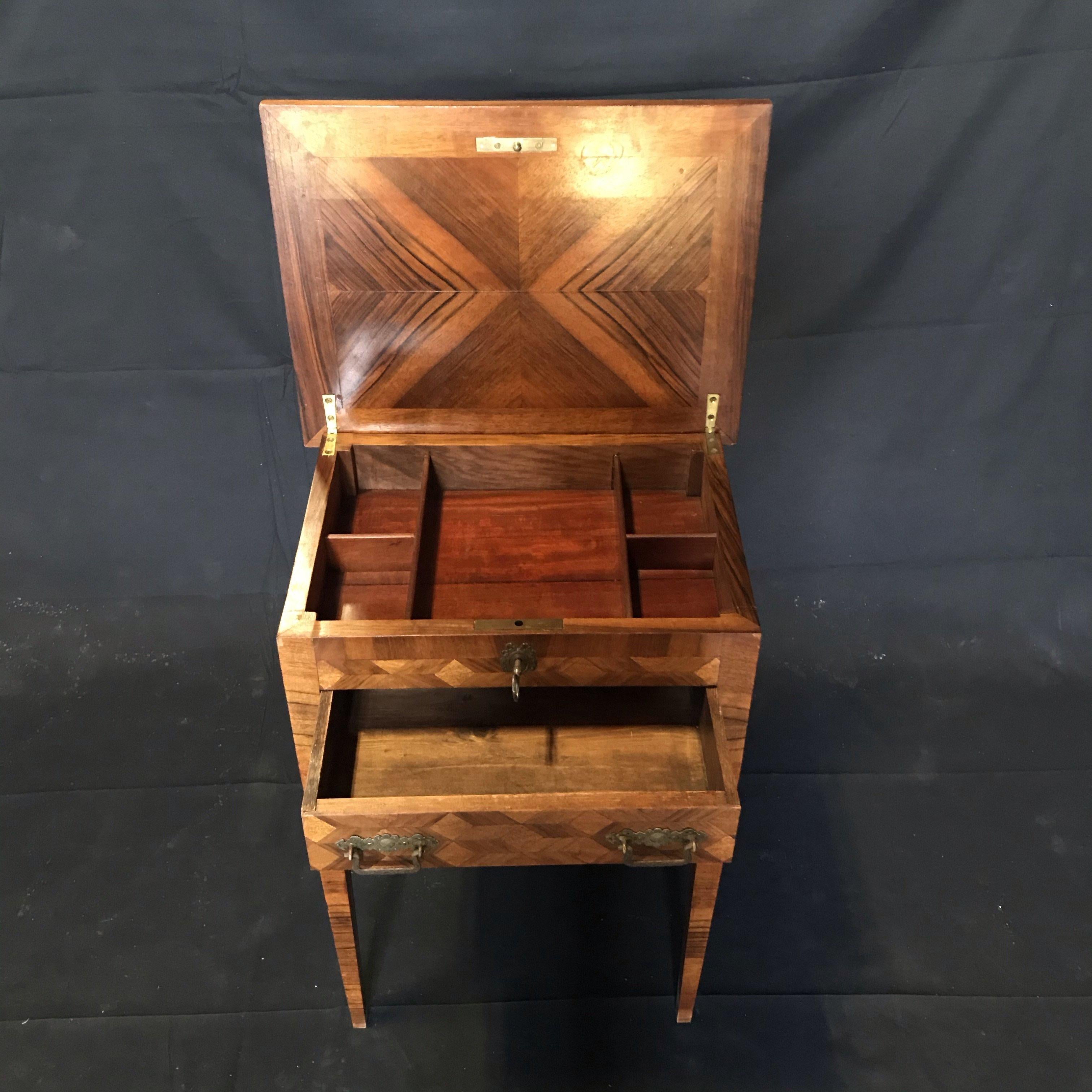 Bought in the South of France, this beautiful parquetry French walnut side table can also serve as a nightstand or sewing table. The top opens to reveal one large center and four side compartments with drawer underneath. Comes with original working