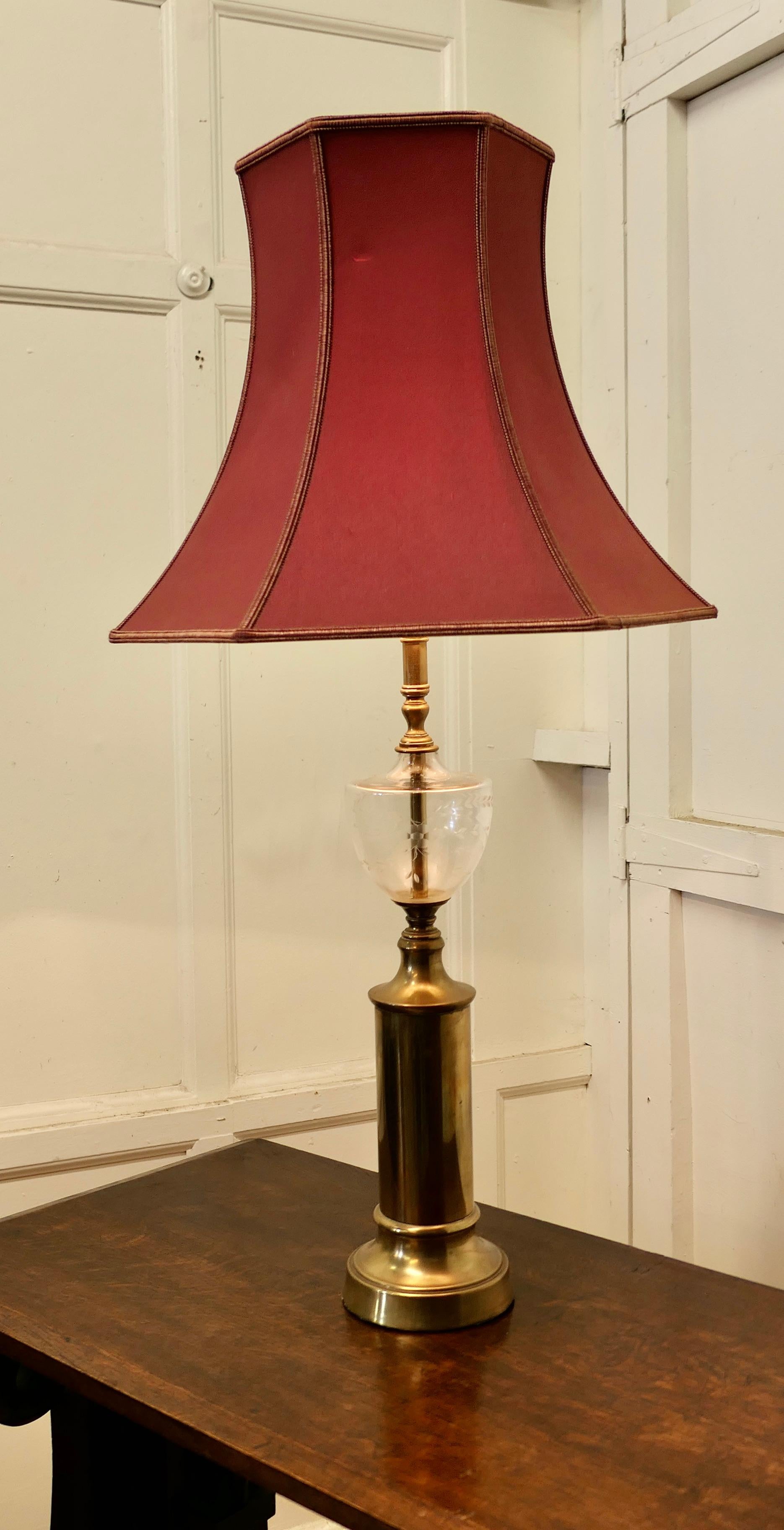 Lovely Glass and Brass Table Lamp 

A beautiful lamp it is designed to look like a Victorian oil lamp with a etched glass reservoir it is set on a tall brass base, and has a large red shade which can be included if wished

The lamp  is in good