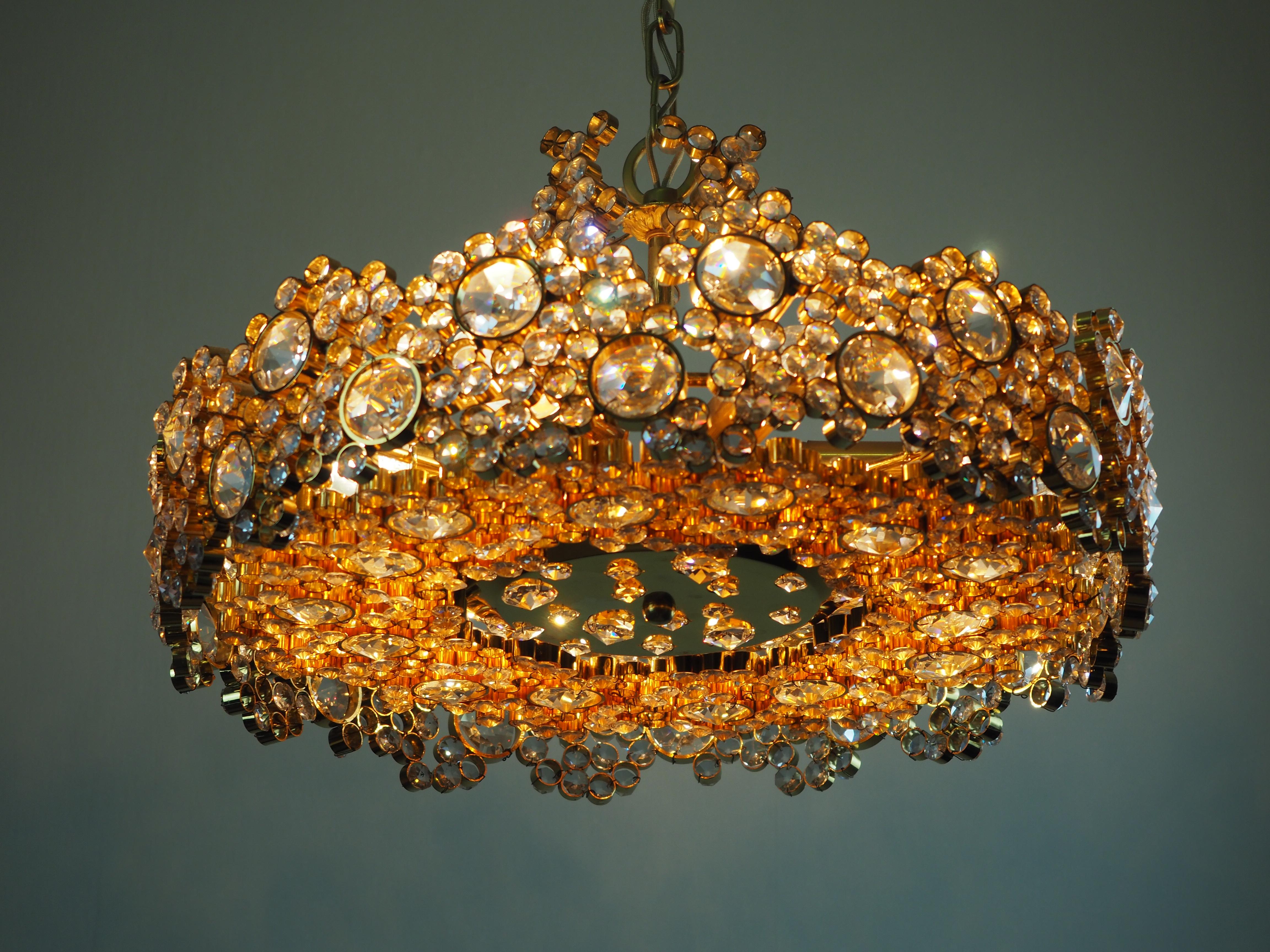 A lovely 24-karat gold plated brass and cut-crystal chandelier attributed to Lobmeyr, Austria, circa 1960s.

The chandelier needs eight x e14 standard screw bulbs for illuminate.

The condition is excellent.



 