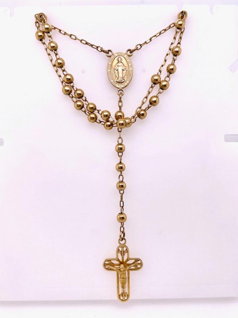 Fine rosary, with cut-out cross on bottom.  14K yellow gold.  The chain is 24